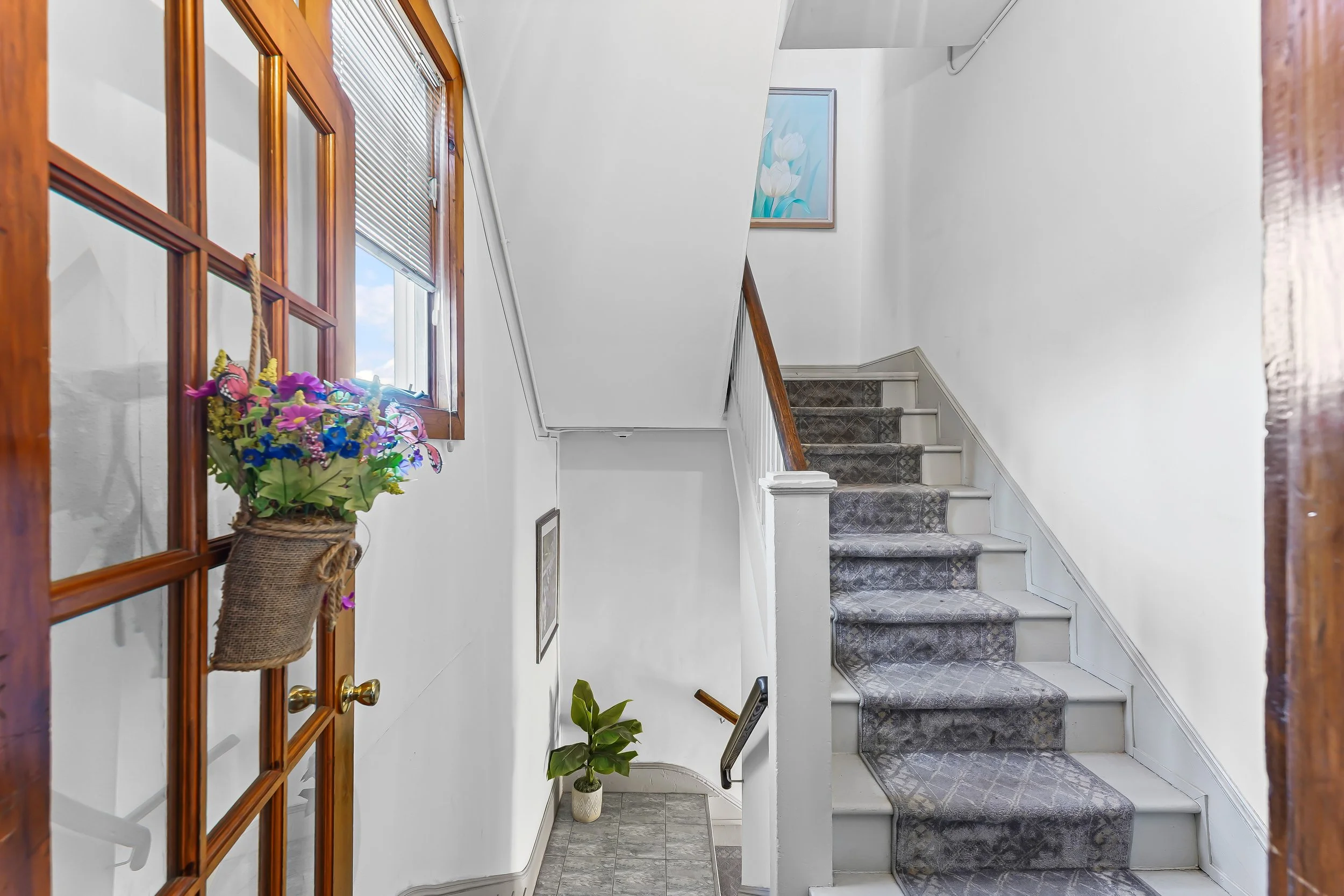 Indoor staircase with gray patterned carpet of a multifamily apartment building.  In a small town, it could be Kennett Square, Avondale, New Garden, Pocopson, Chadds Ford, Unionville, Oxford. Any of the beautiful towns in Southern Chester County.