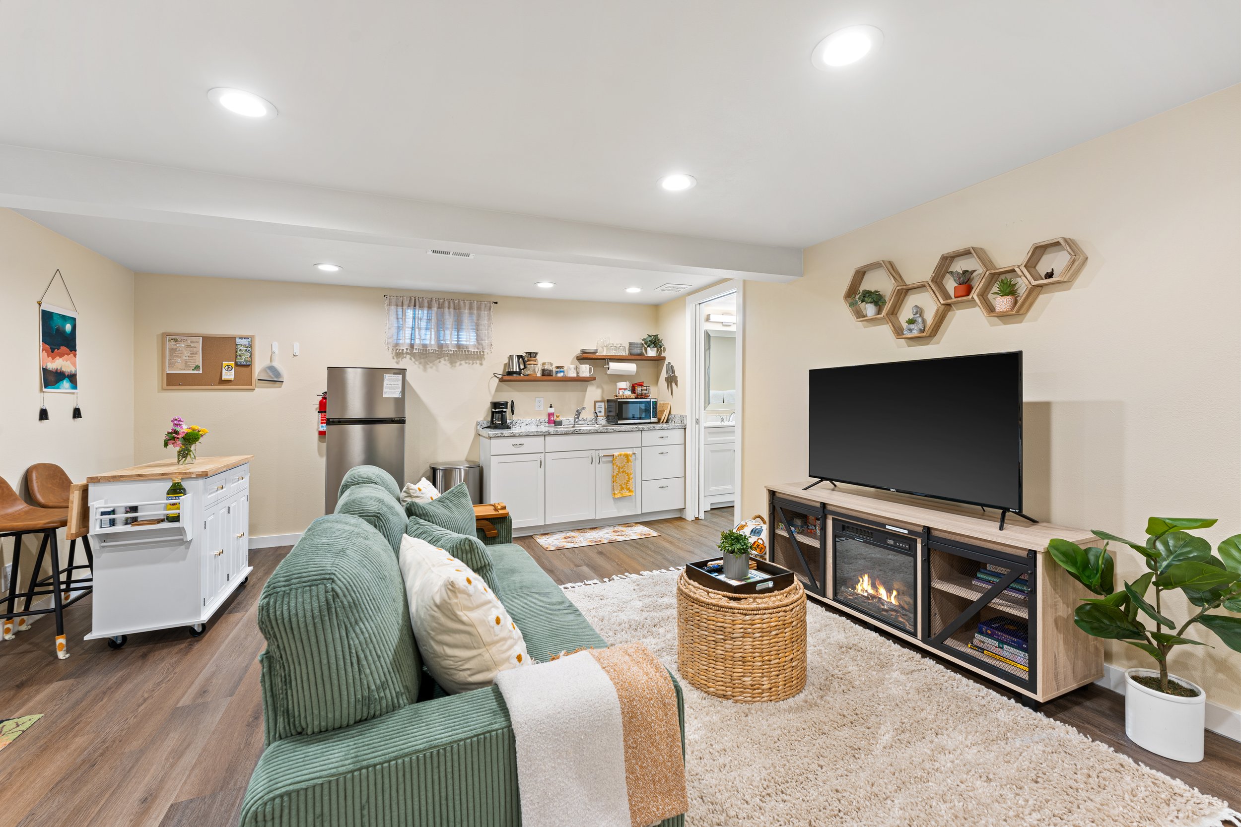 Relax in our cozy living area, featuring a comfortable couch, a 50-inch Roku TV for entertainment, and a warm electric fireplace to set the perfect mood. The fully equipped kitchenette is ready for you to enjoy a snack or meal during your visit!
