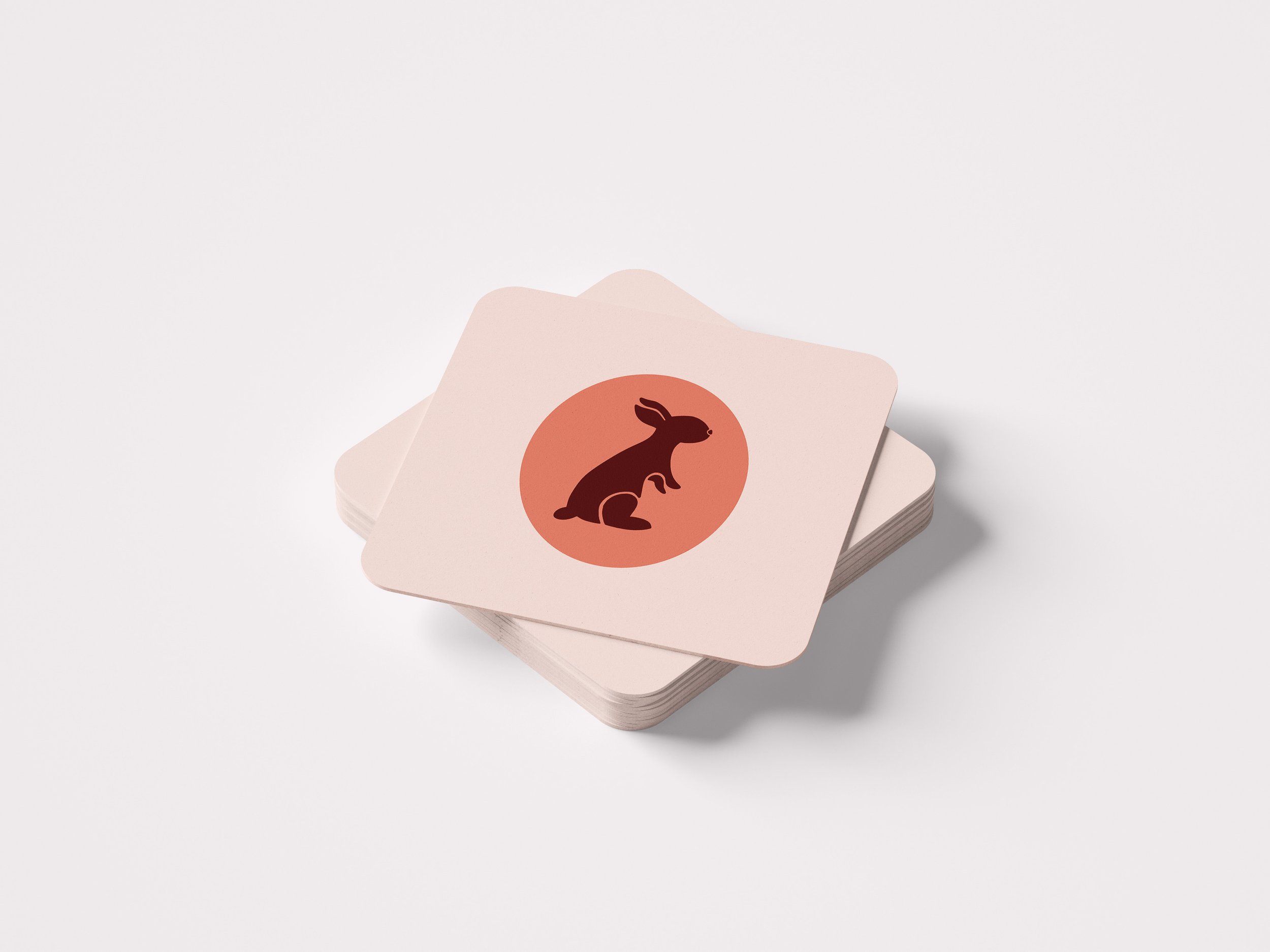 A stack of branded El Conejo square coasters