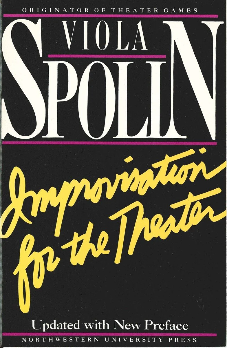 Book cover of 'The Viola Spolin' titled 'Improv for the Theater' with a black background, large white and yellow text, and purple lines.