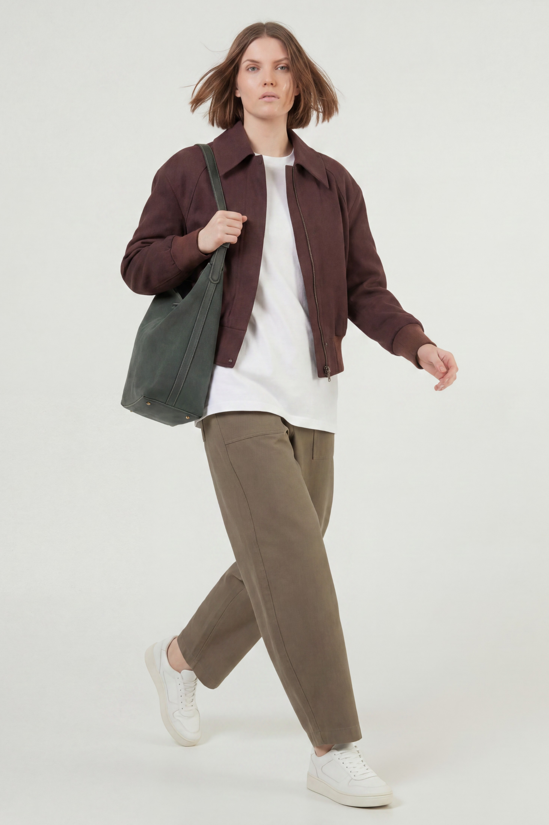 Brunette model in motion while wearing the faux suede bomber
