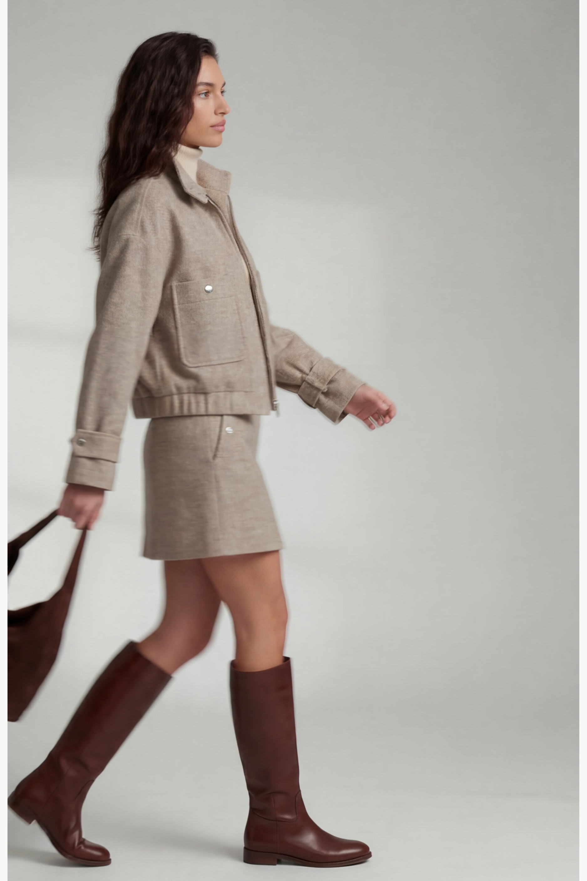 Side view of model walking wearing the Izzy Bomber, Izzy Skirt and Cashmere Turtleneck