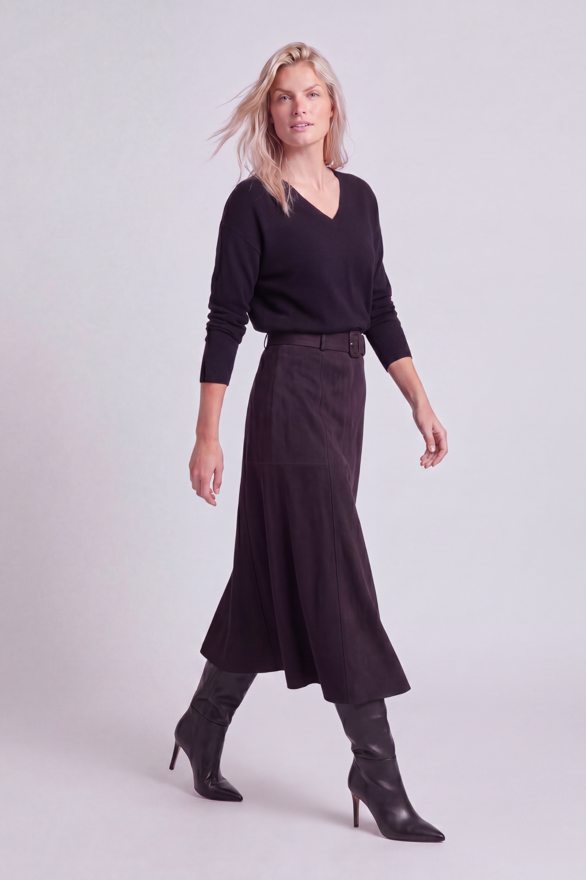Model shown in motion wearing the black a-line faux suede skirt