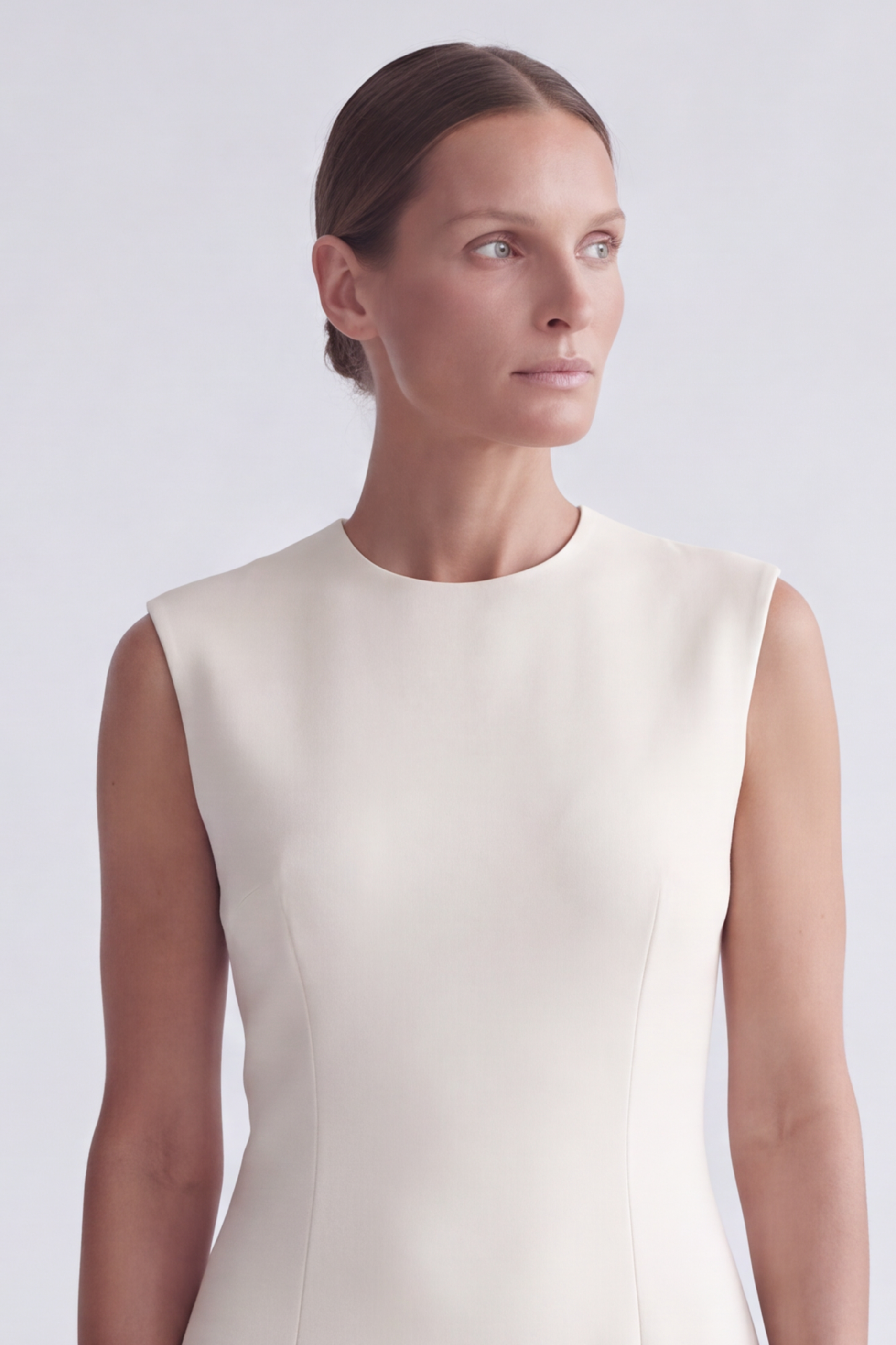 Shot of model from the bust up wearing the sheath dress in cream crepe