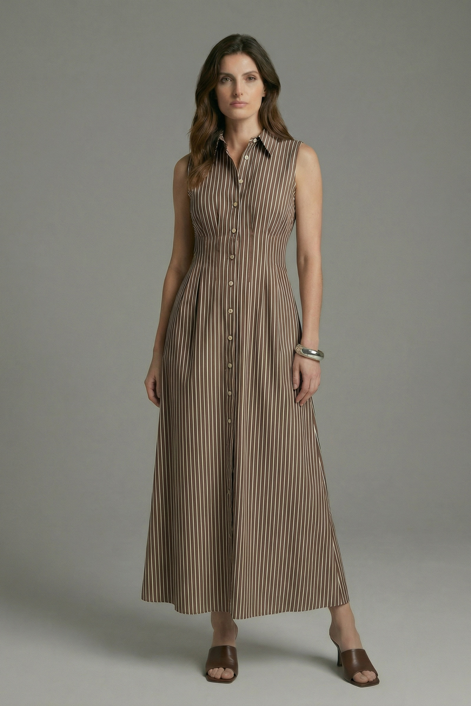 Model in studio standing wearing the brown/white stripe Sleeveless Shirt Dress