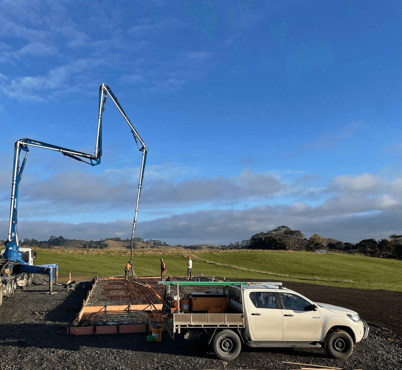 Concrete pump pouring concrete into a prepped rural concrete shed slab