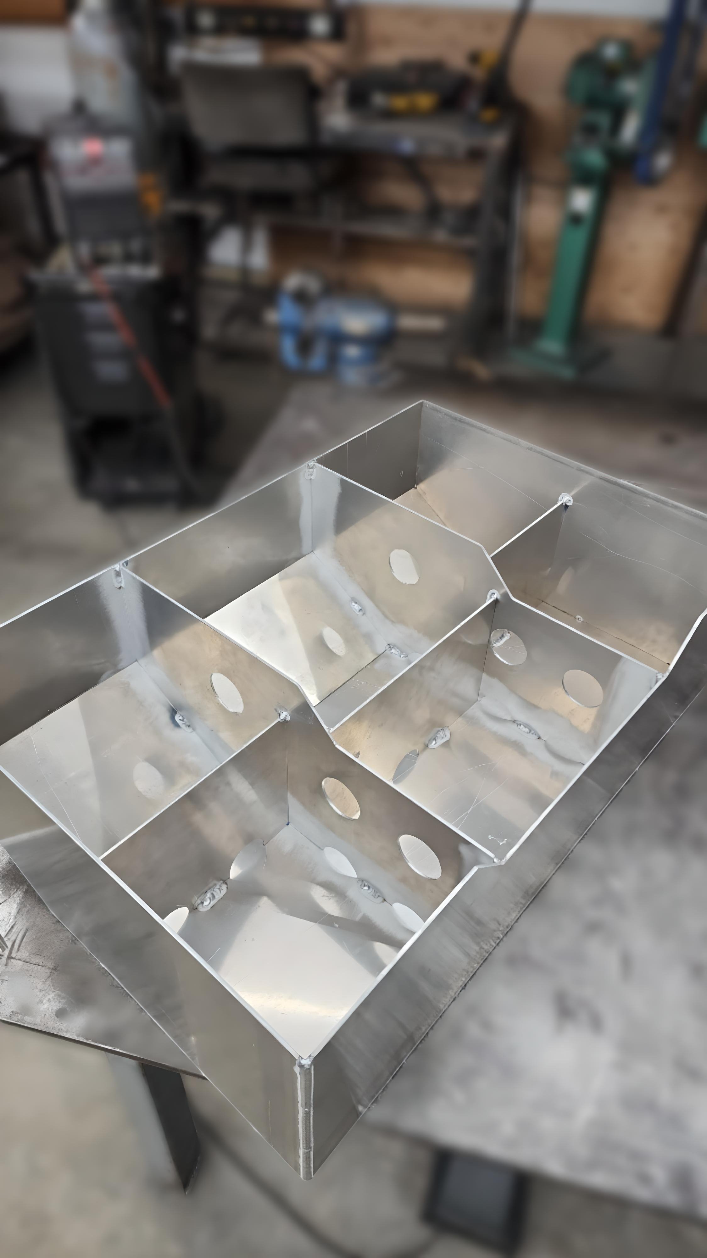 Metallic structure with multiple compartments and round cutouts, workshop background