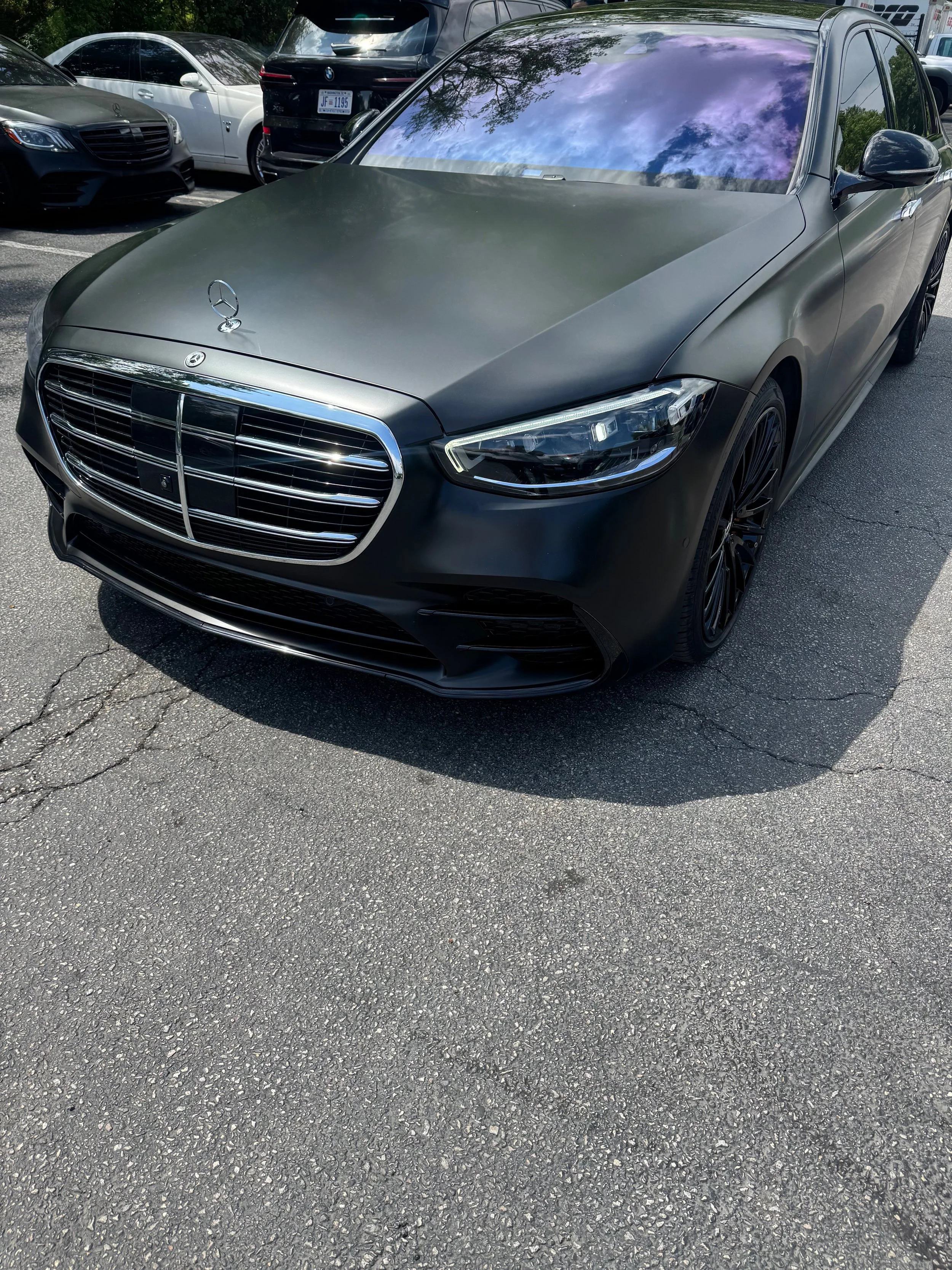 Black Mercedes-Benz car with matte finish parked in a parking lot new vinyl wrap