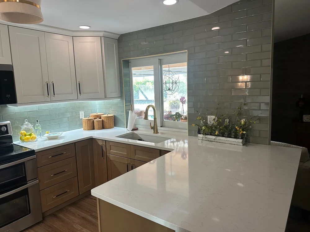 After: Two-tone kitchen remodel with quartz peninsula and glass tile backsplash - McGregor, Fort Myers FL