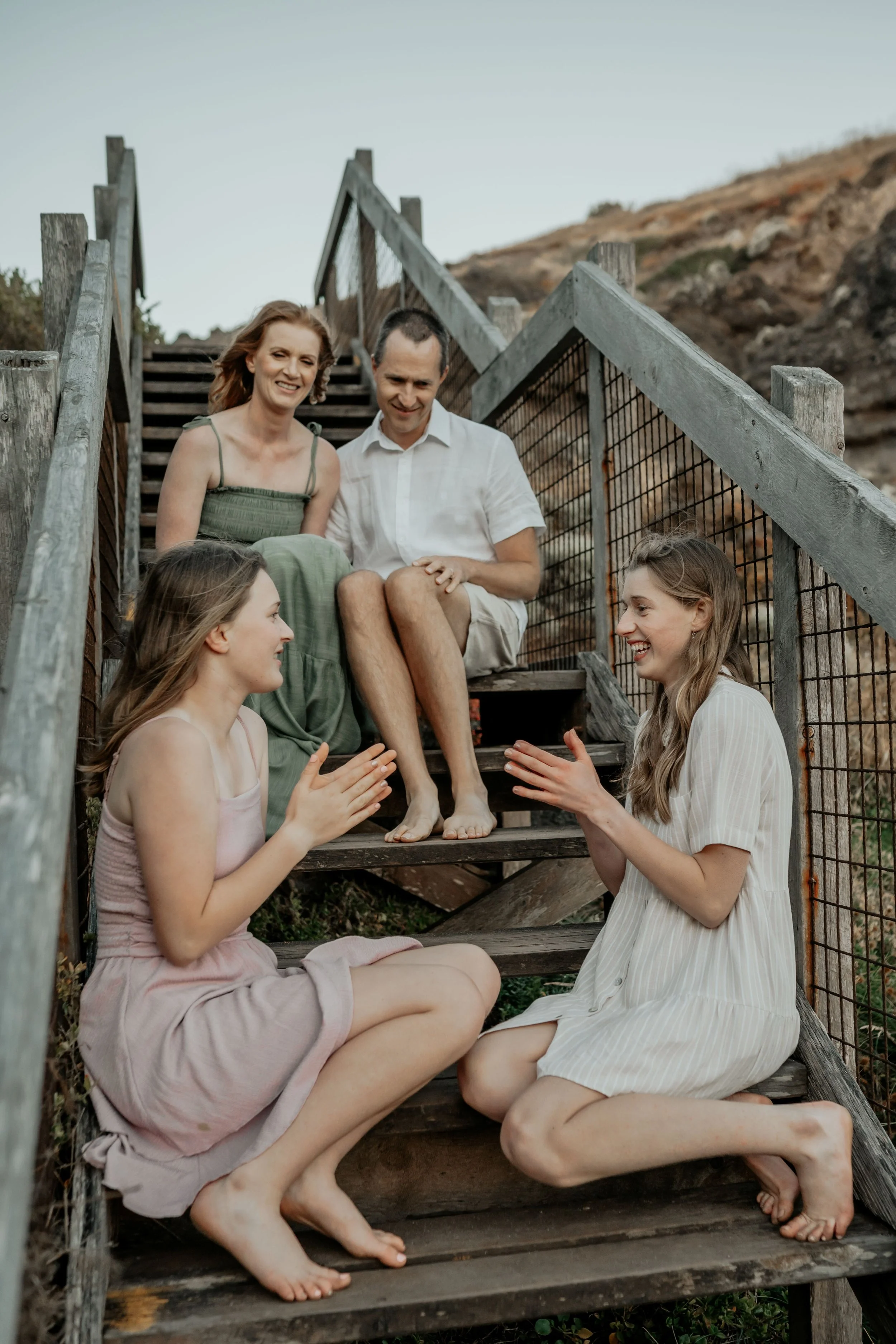 Mother and father watch their teenage daughters play hand claps