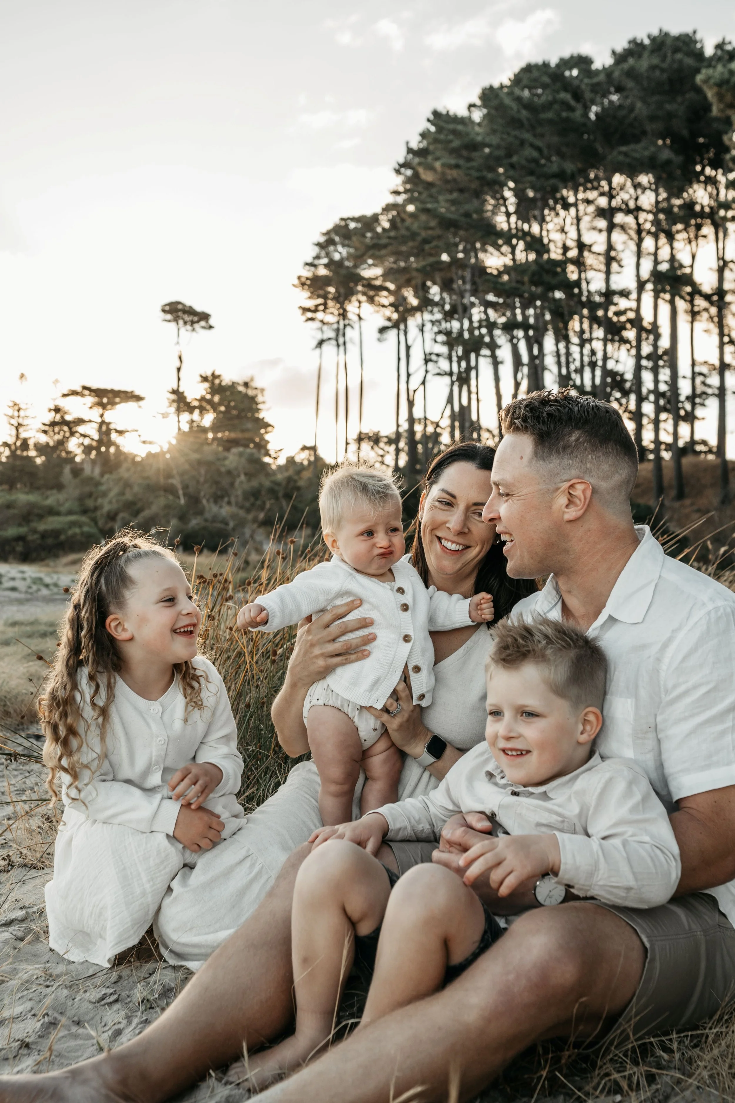 A family sitting talking and laughing on the beach