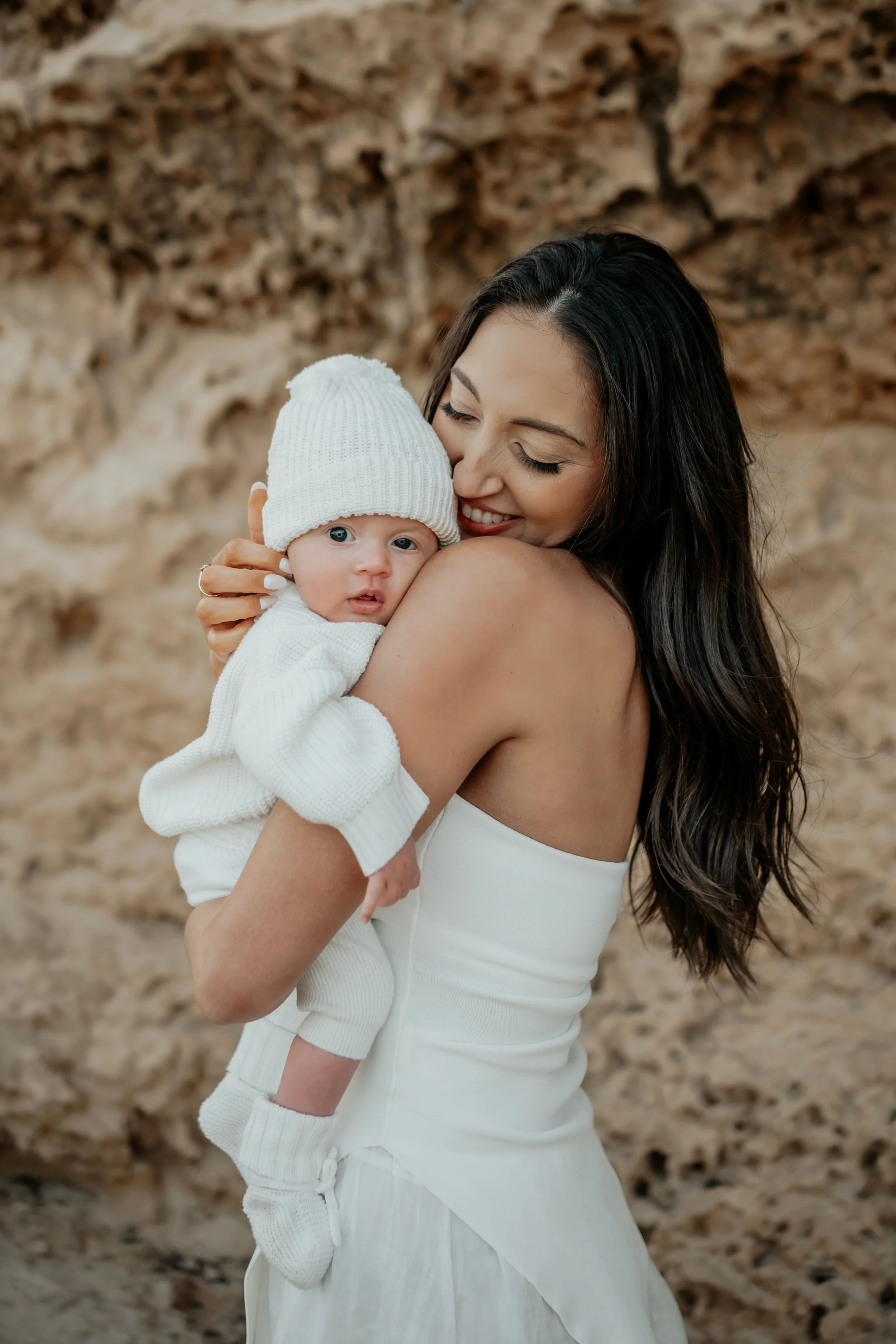 A mother holding her baby boy close 