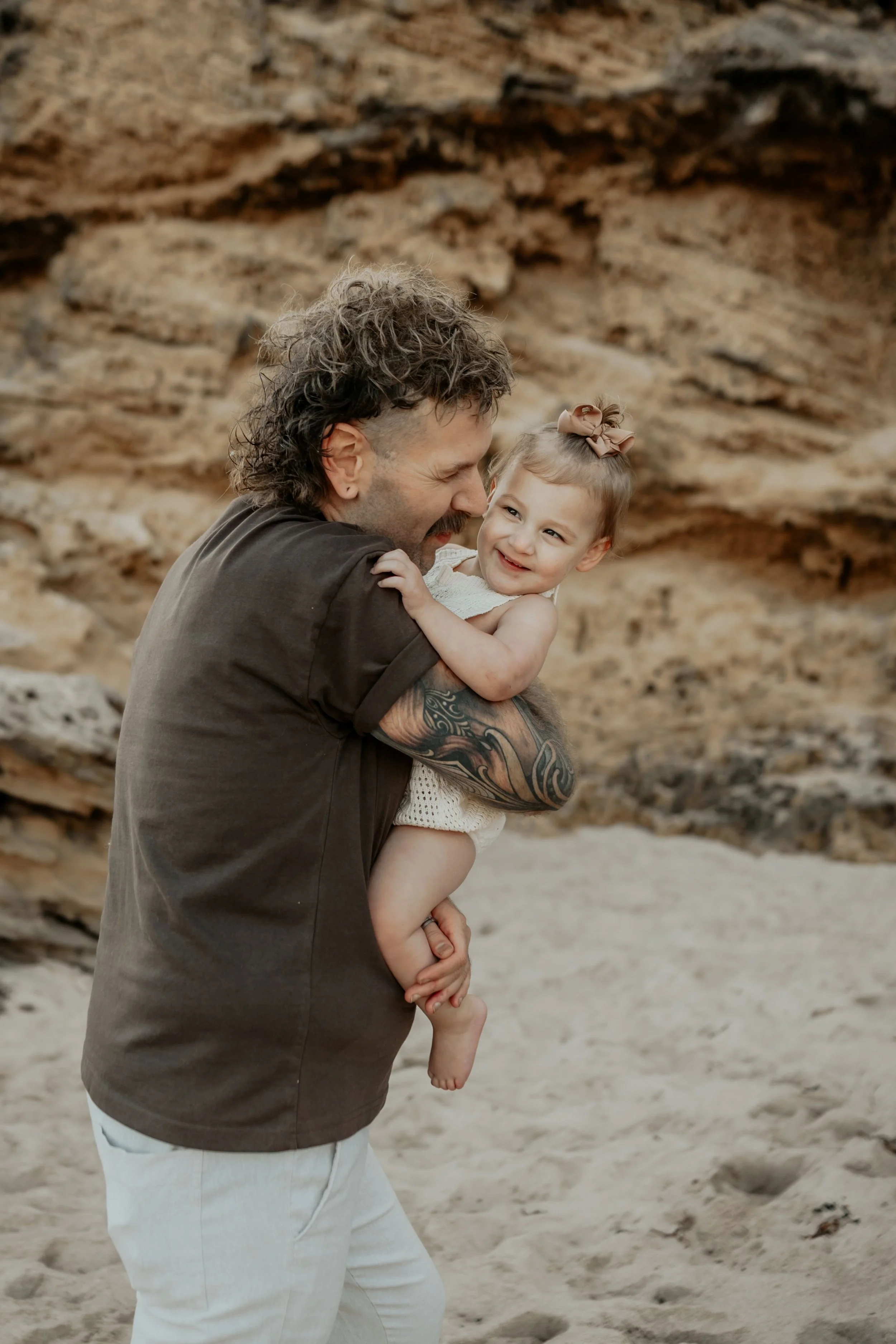 A father nuzzling his toddler daughter