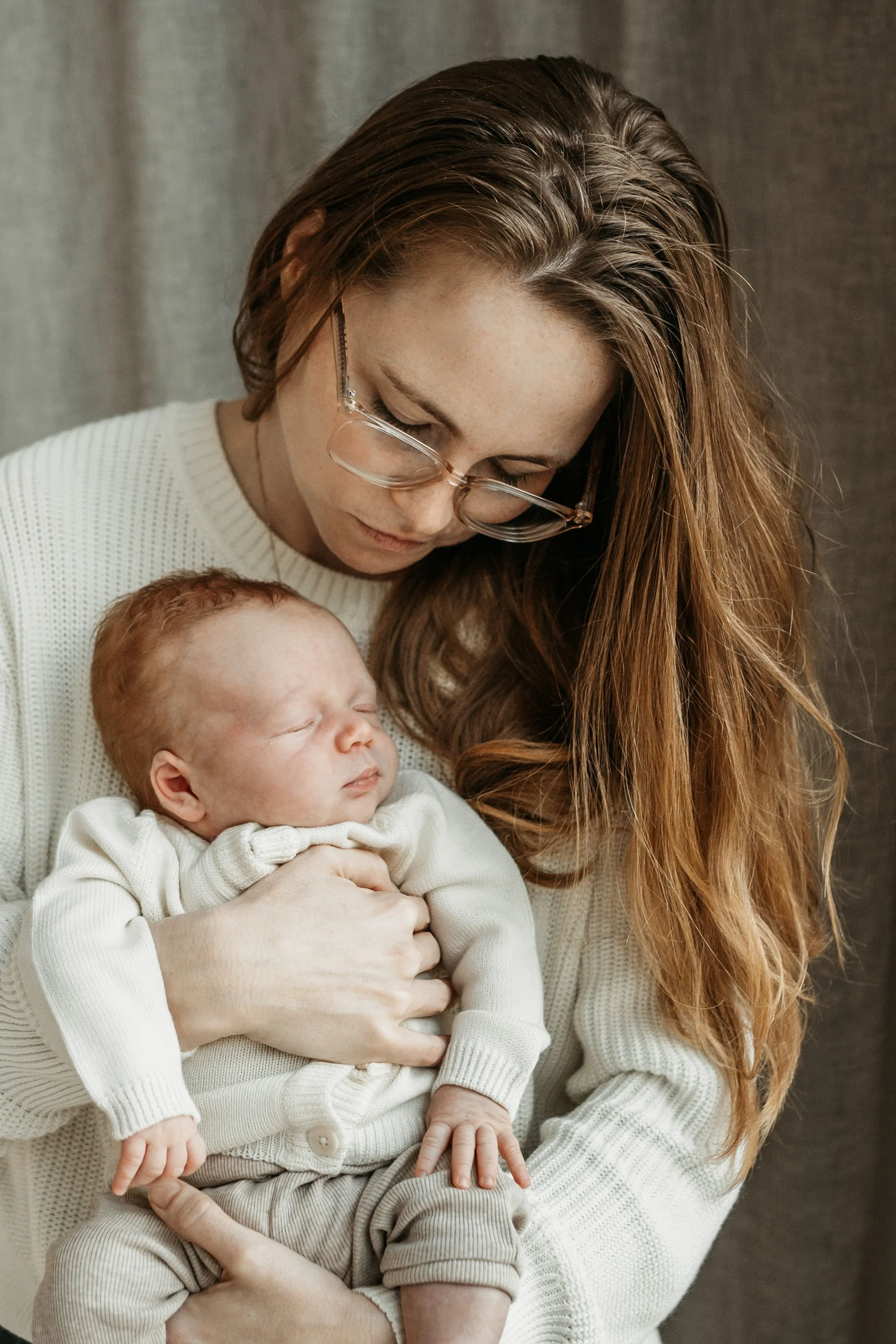 A mother adores her newborn baby during a photography session at home