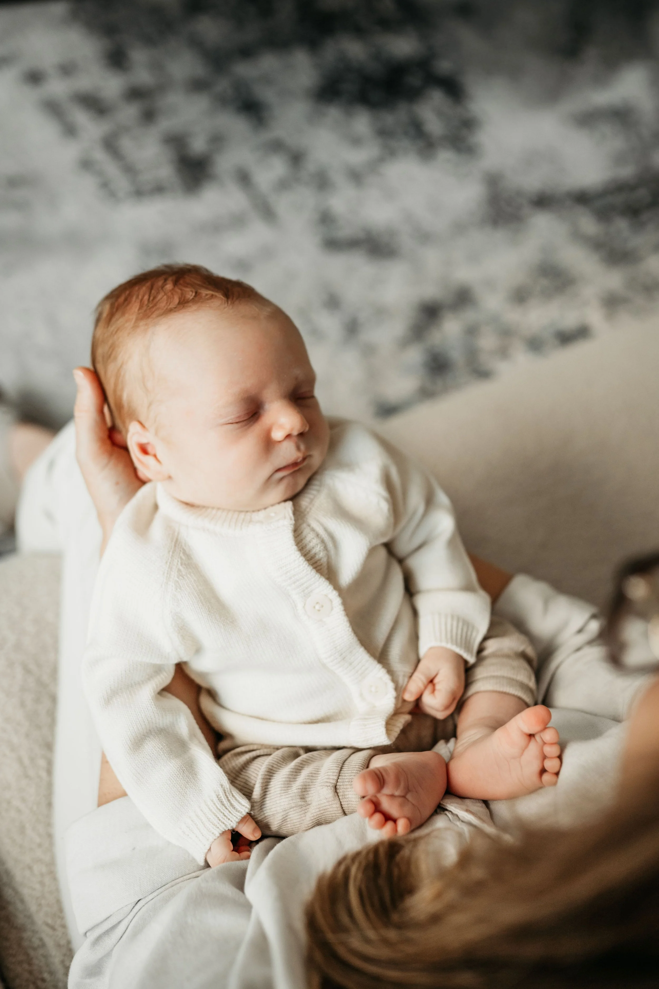 A newborn baby being cradled in his mothers arms