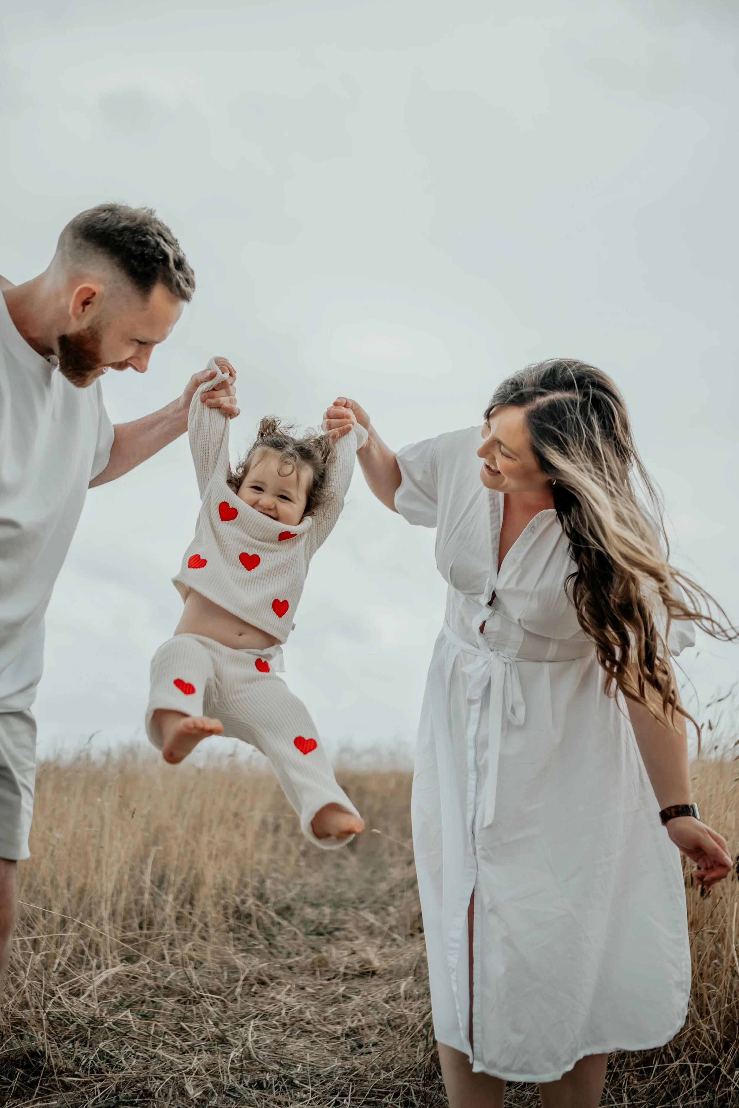 Mum and Dad swing their child between them