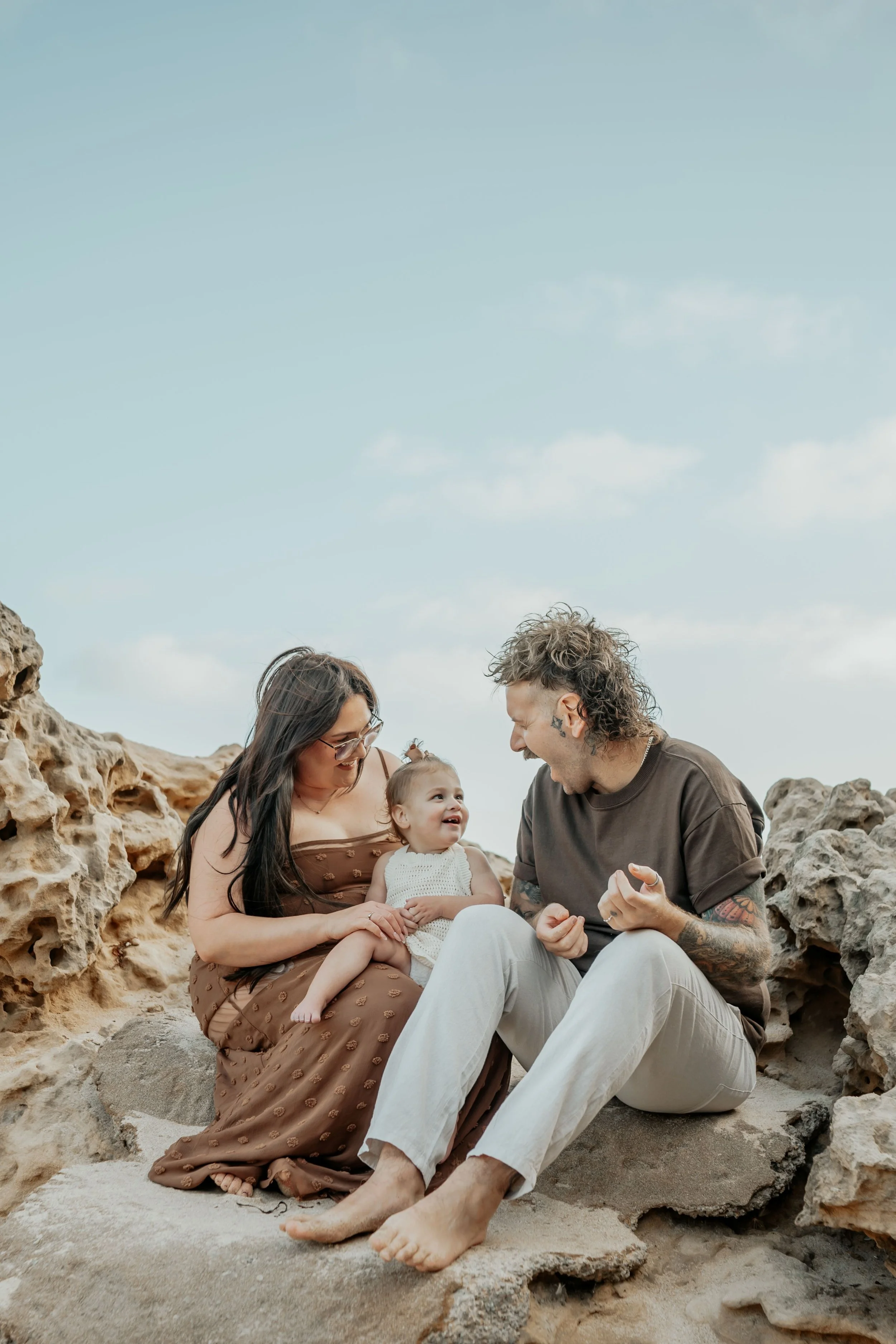 A mother and father chat and laugh with their toddler