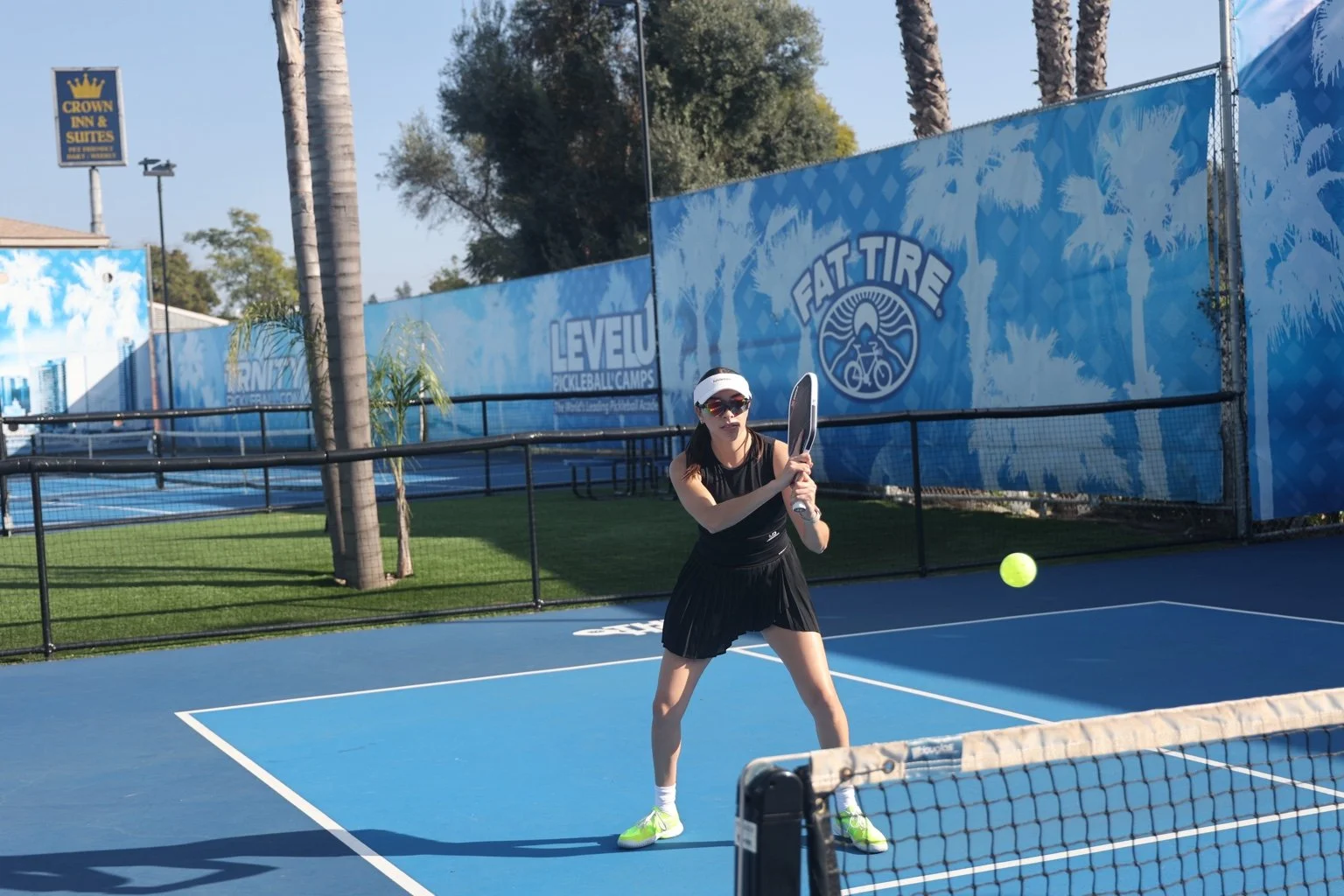 Elitza Lopez preparing a two-handed backhand on an outdoor pickleball court.