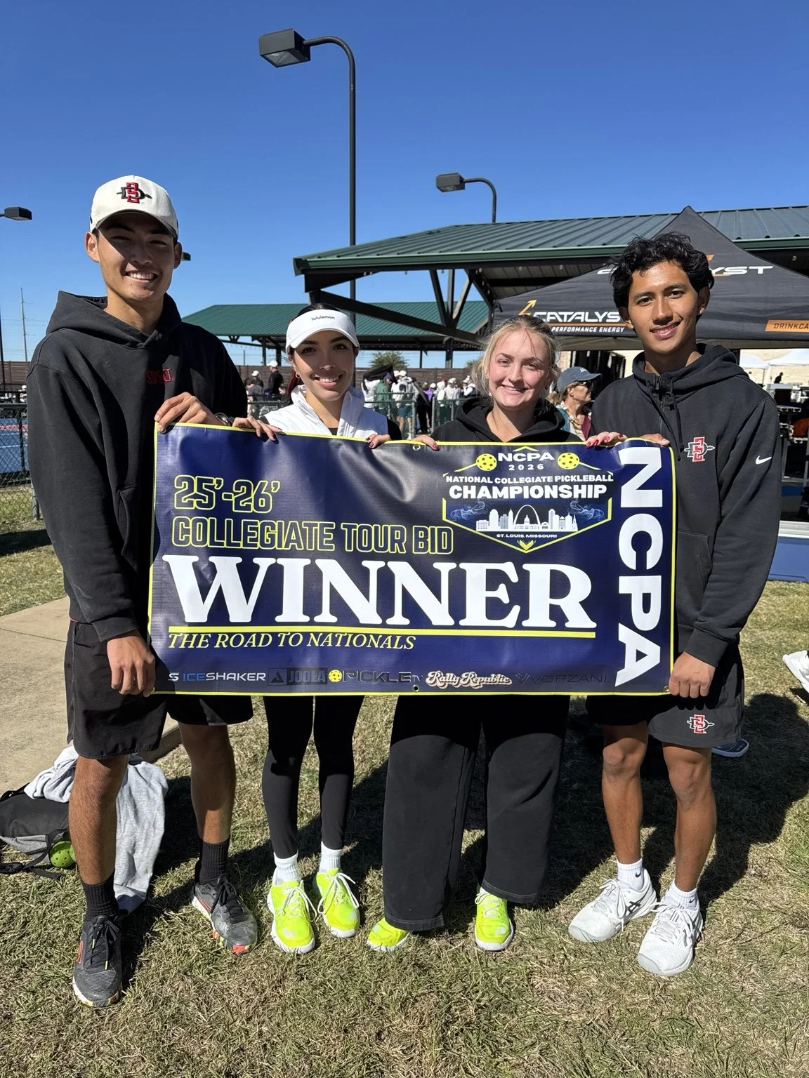 Elitza Lopez and three teammates holding an NCPA collegiate tour bid winner banner.