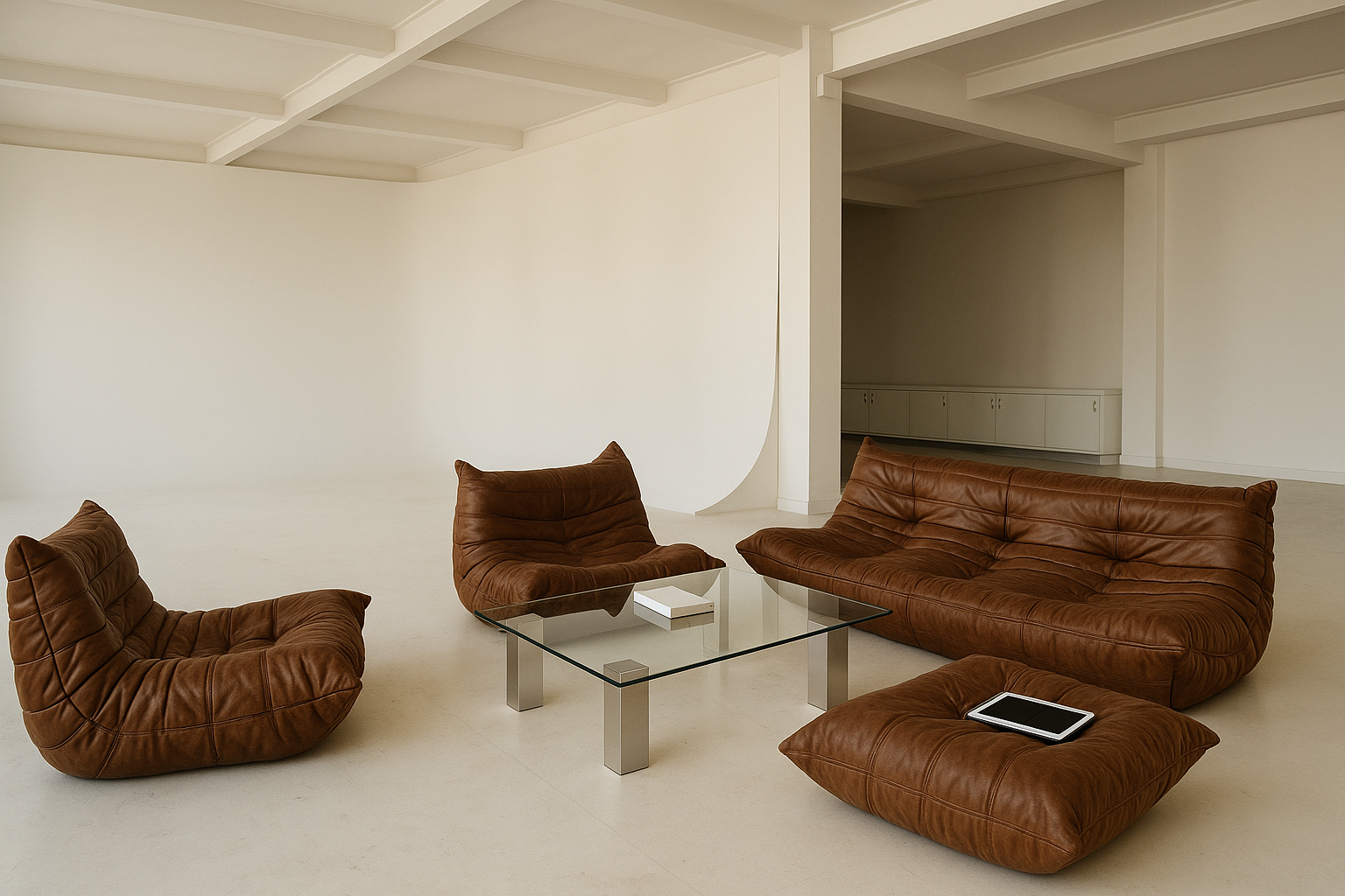 Minimalistische woonkamer met bruine lederen banken, glazen salontafel en tablet op de vloer.