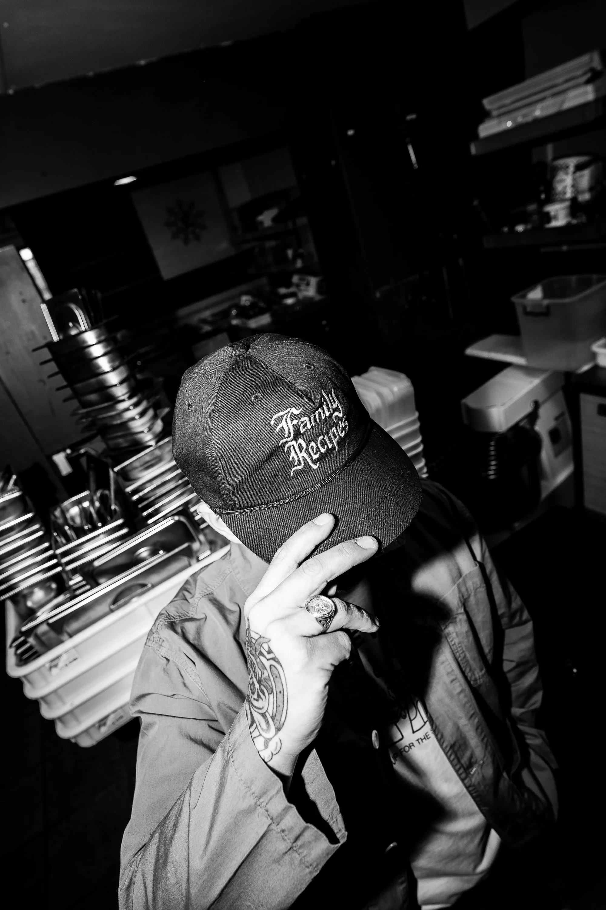 Person wearing a cap that says 'Family Recipes' in a kitchen or food preparation area.