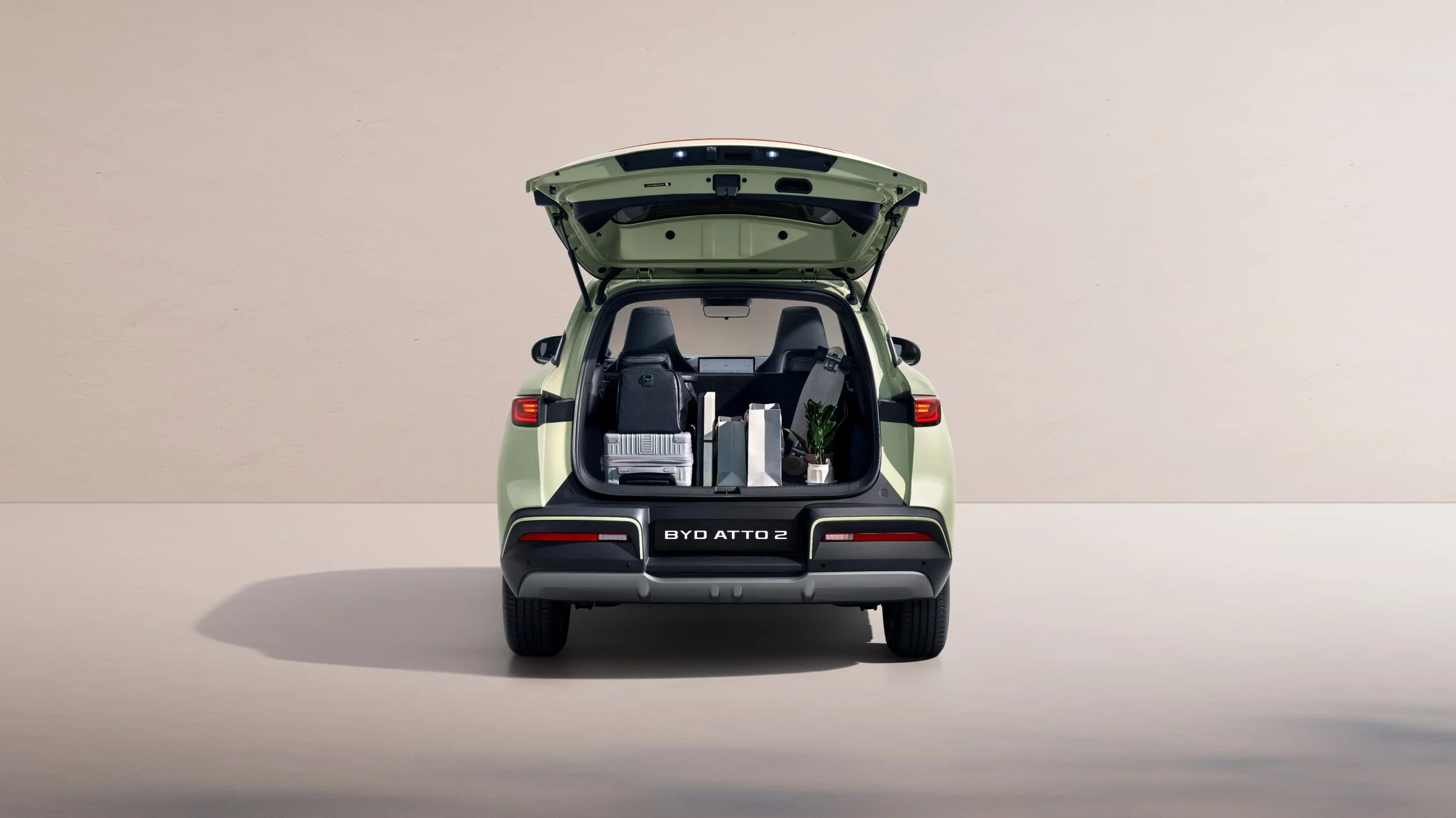Kompaktowy elektryczny SUV BYD ATTO 2. Samochód widoczny od od tyłu z otwartą klapą bagażnika.