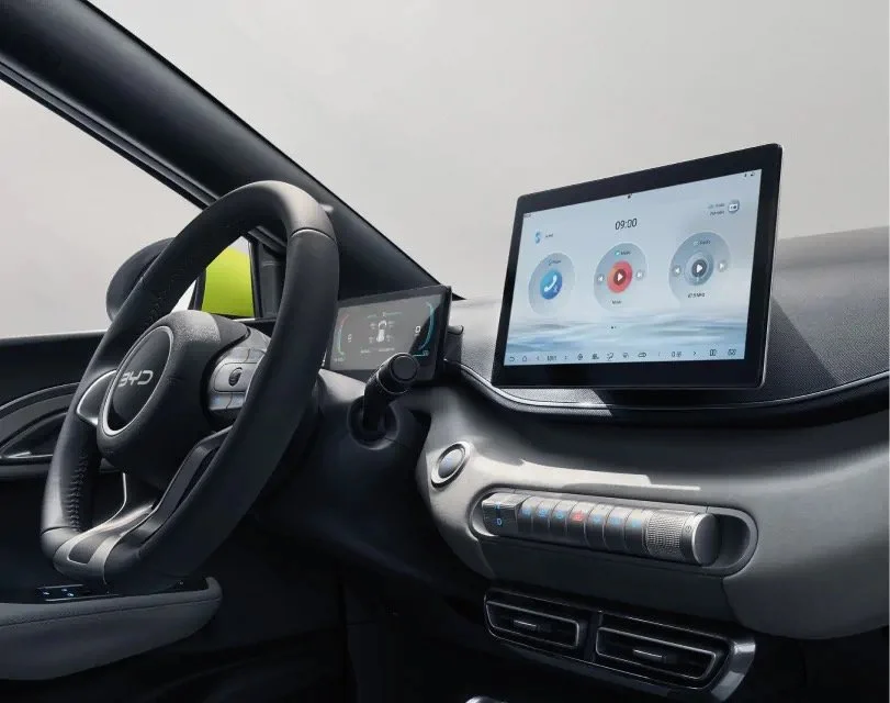 Wnętrze BYD Dolphin Surf – widoczna kierownica, cyfrowy zestaw wskaźników oraz duży ekran dotykowy z ikonami aplikacji.