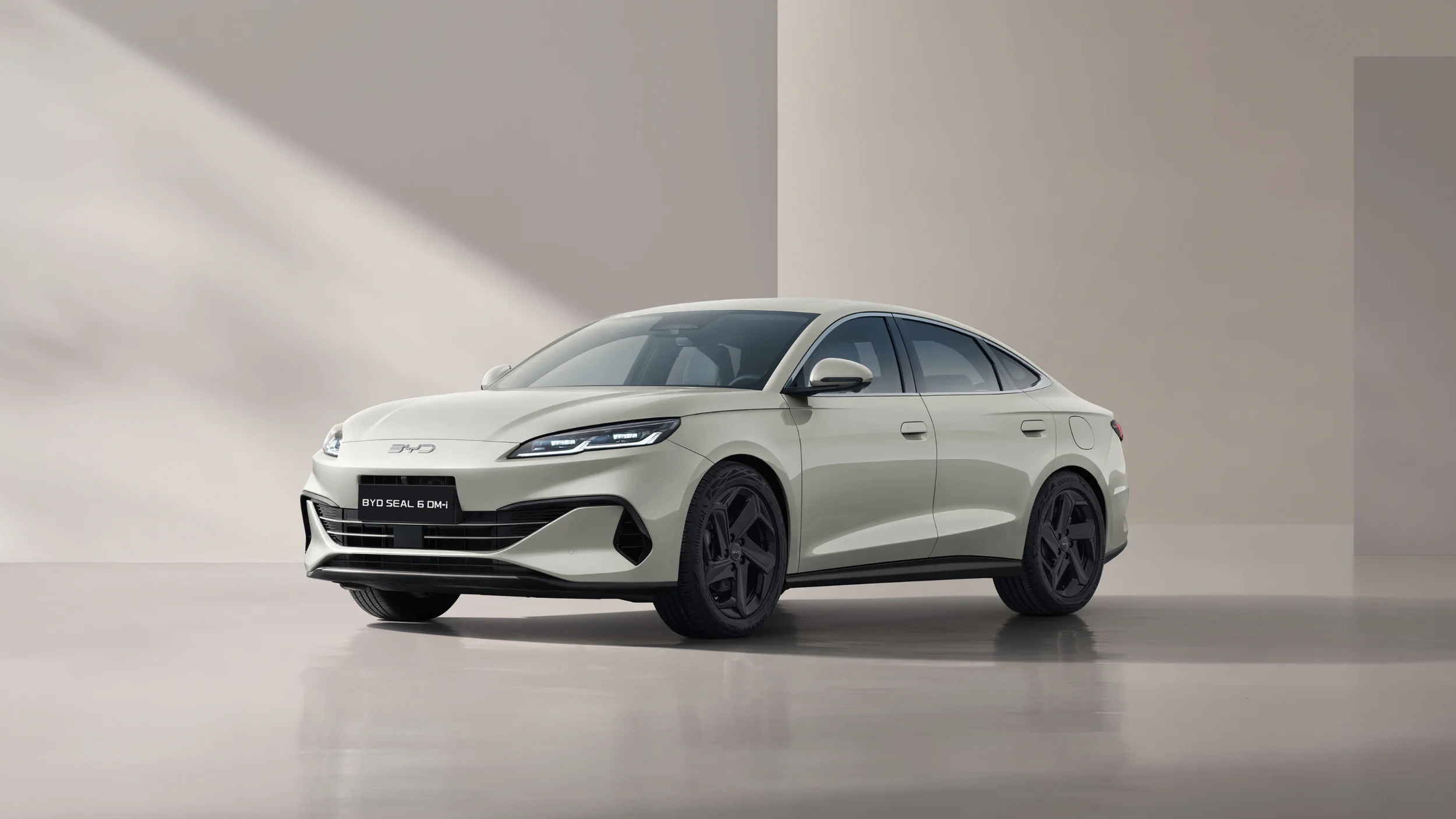 Hybrydowe kombi BYD Seal 6 DM-i w piaskowym kolorze "Sandstone" w minimalistycznym, dobrze oświetlonym studiu.