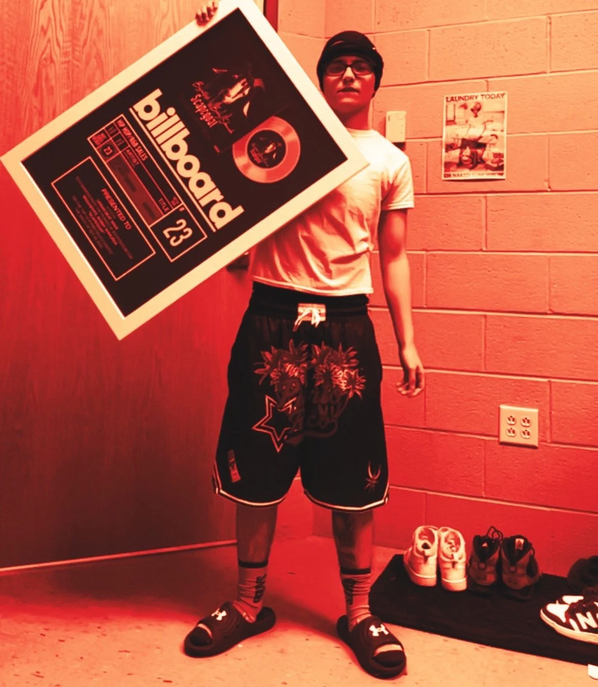 People walking and taking photos in Times Square at night with bright billboards and advertisements.