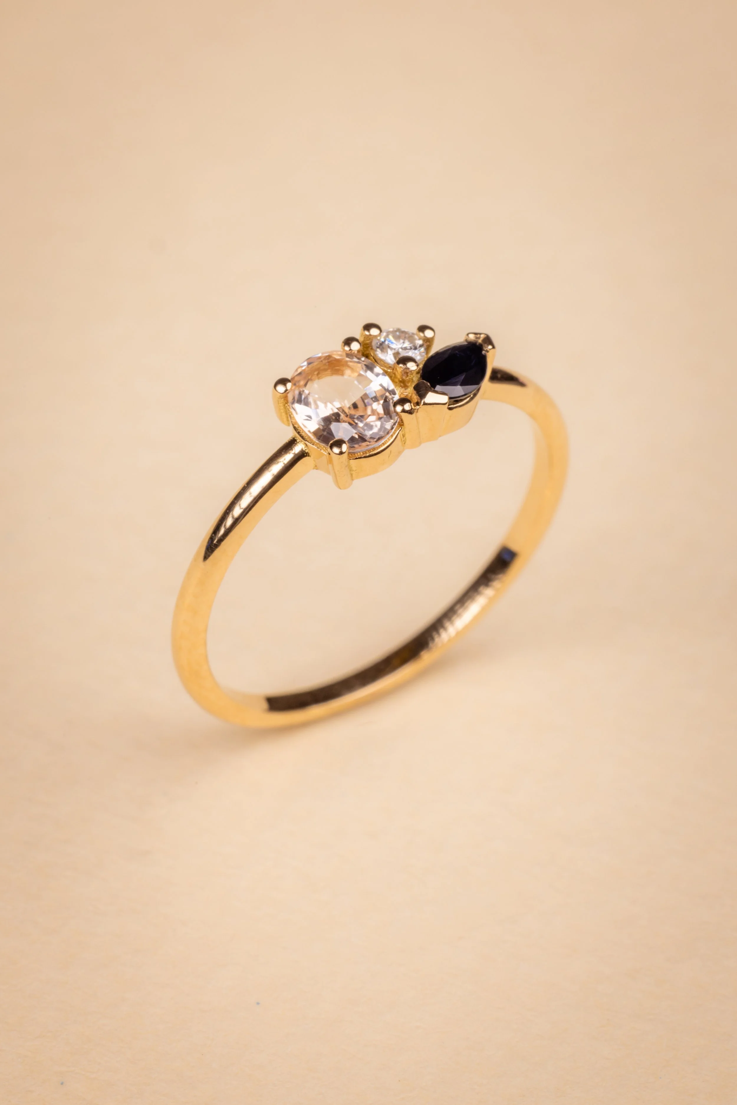 Bague après transformation en or jaune avec trois pierres précieuses : une pierre centrale jaune, un saphir bleu, et un diamant