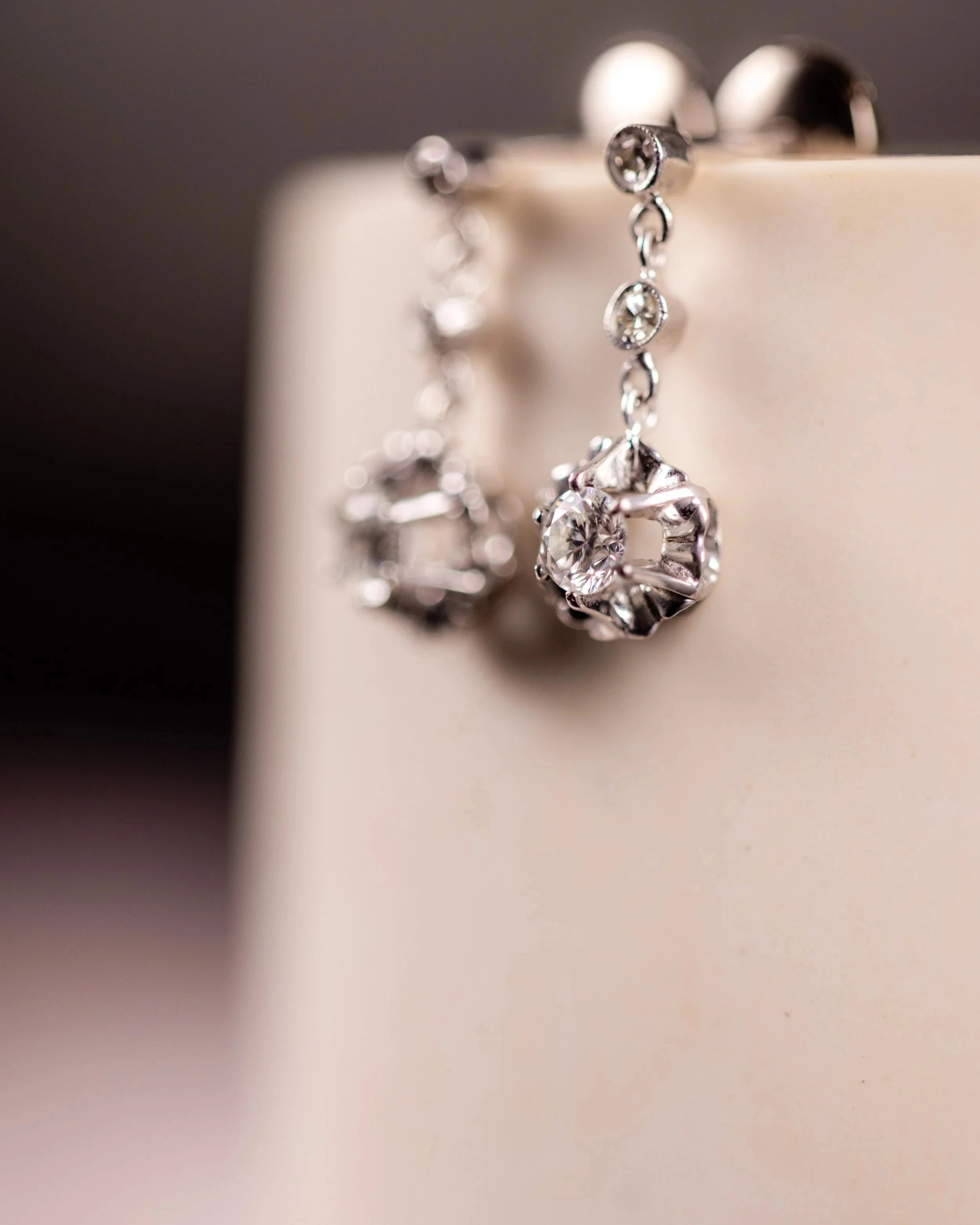 Boucles d'oreilles en or gris avec des diamants  suspendues.