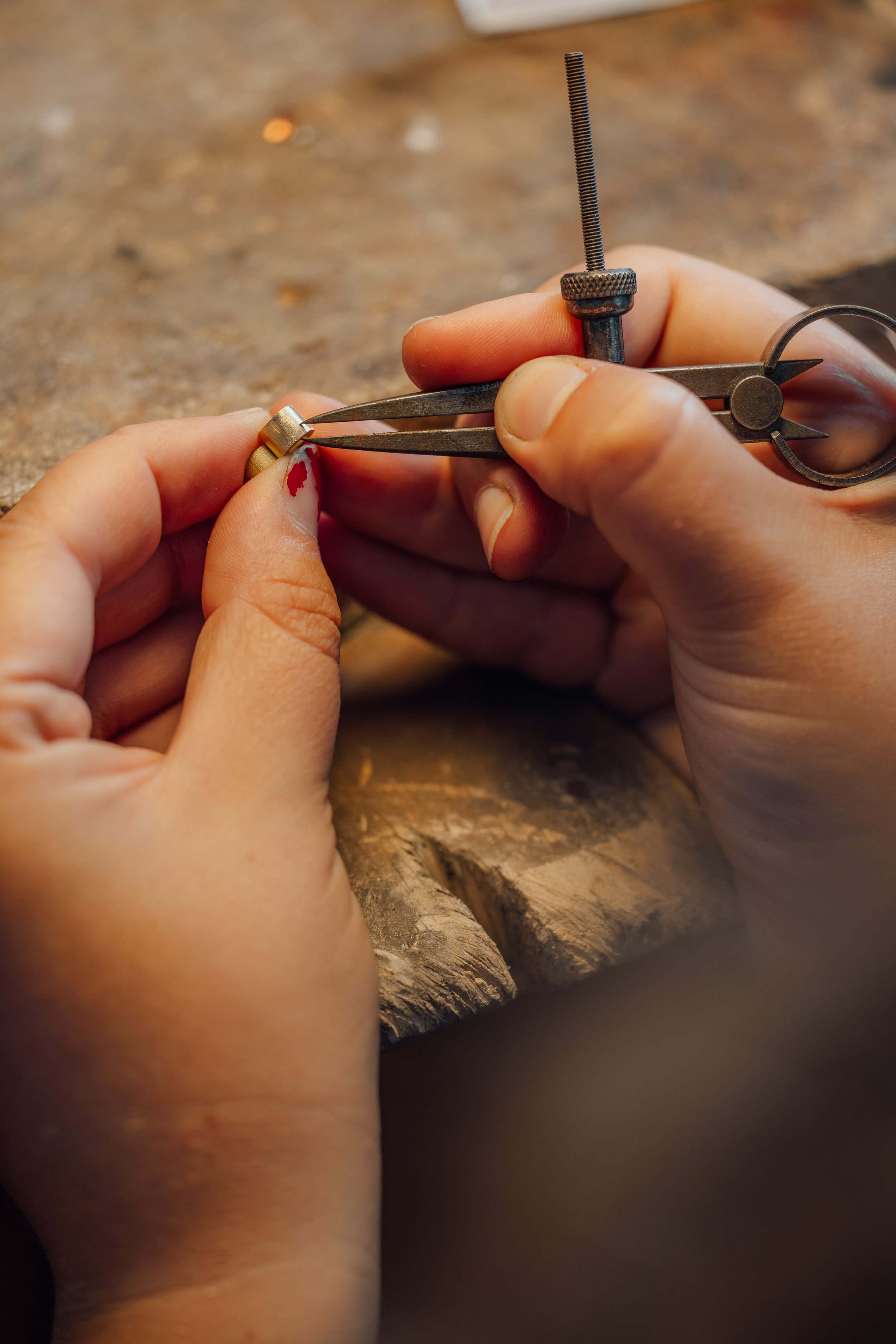 Un artisan joaillier en train de fabriquer un bijou dans son atelier à Montpelliers pinces, possible bijoutier, sur une surface en bois