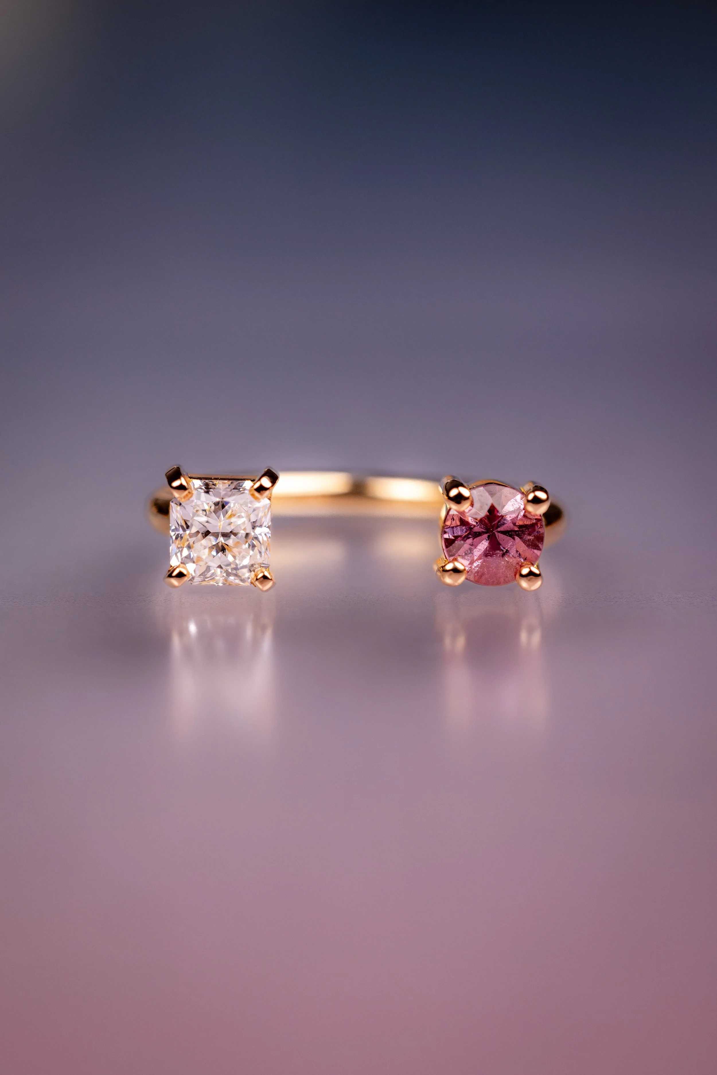 Une bague avec deux pierres précieuses, un diamant et un grenat malaya, chacune fixée par quatre griffes