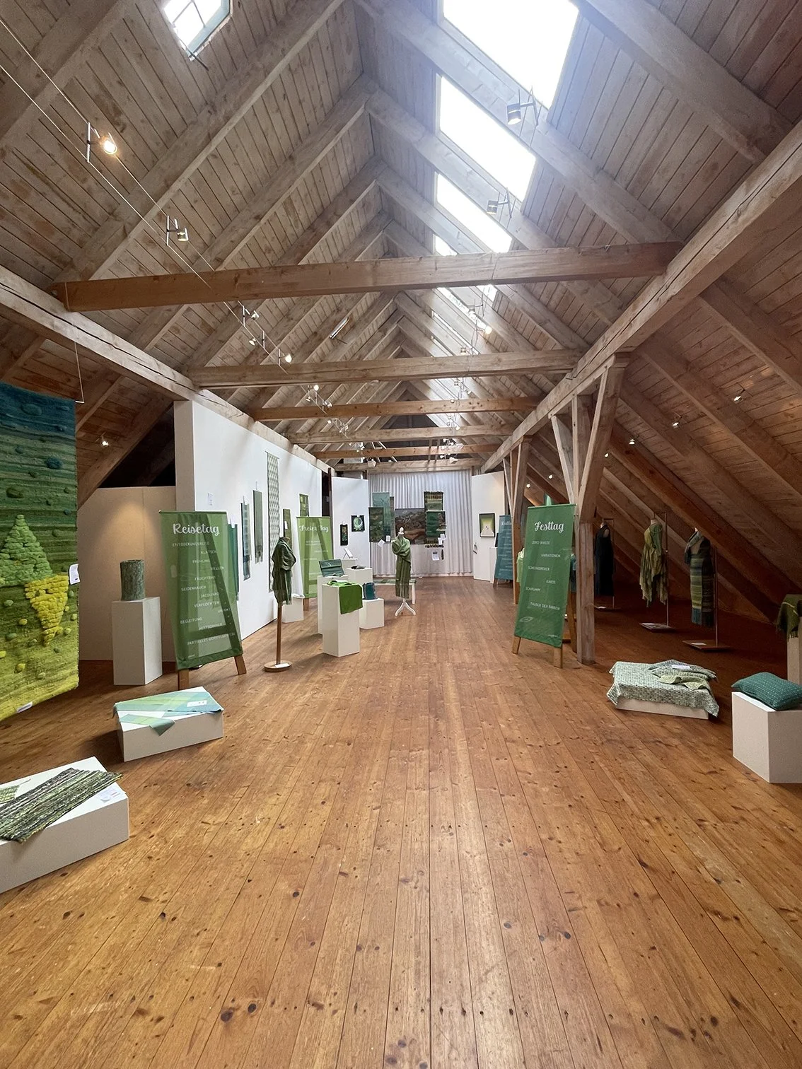 A photo from inside a weaving exhibition showing different woven piceces