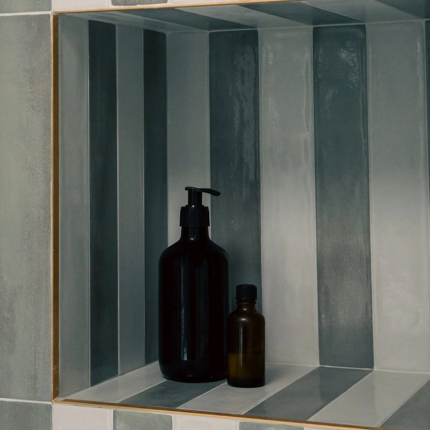Who says shower niches have to blend in?
We chose these bold vertical stripe tiles to turn a simple nook into a standout feature.
Niches are a great opportunity to play with patterns. By selecting your tiles before construction begins, you can plan n