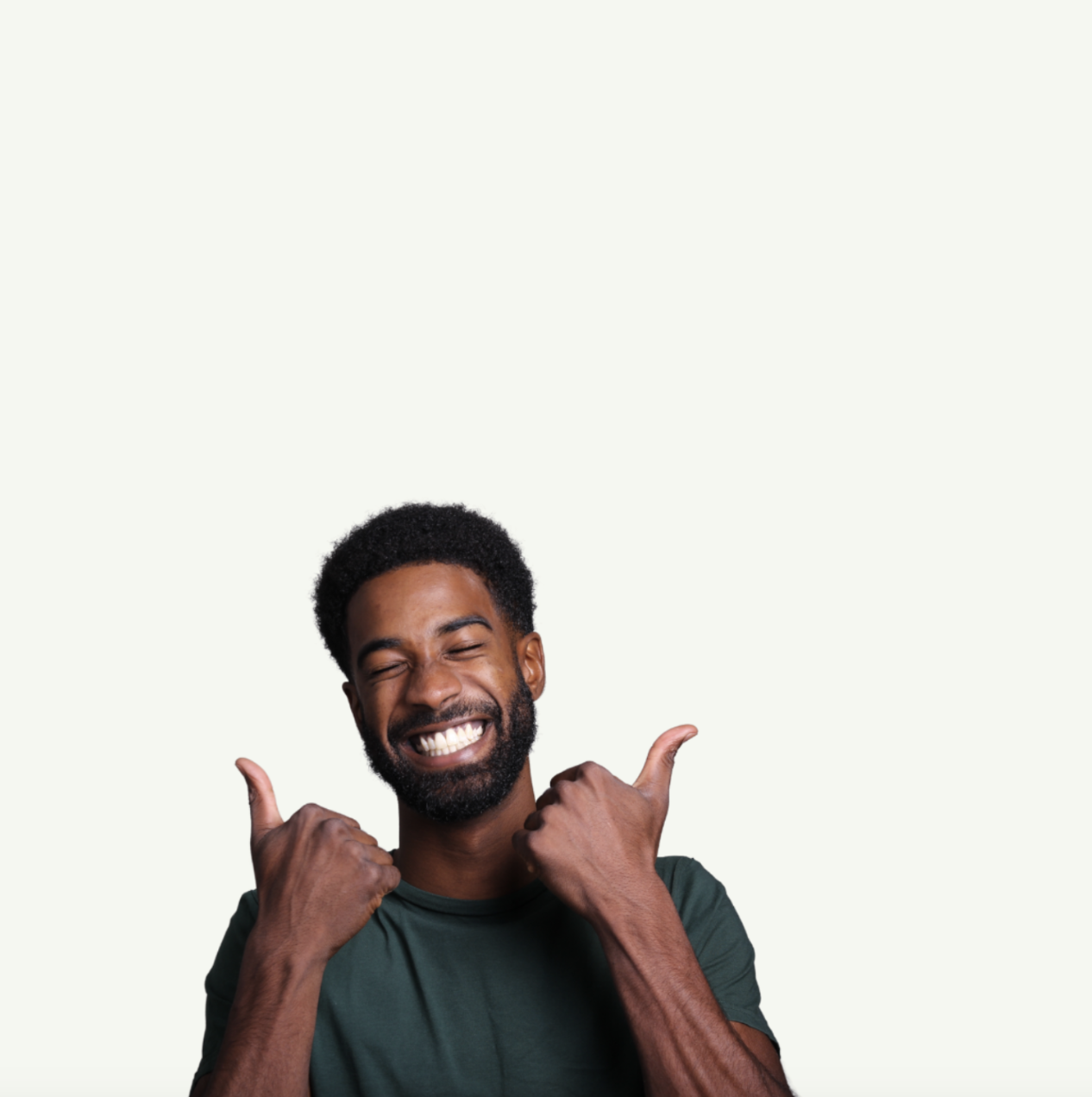 Homme souriant en t-shirt vert levant les pouces en signe d’enthousiasme sur fond clair.