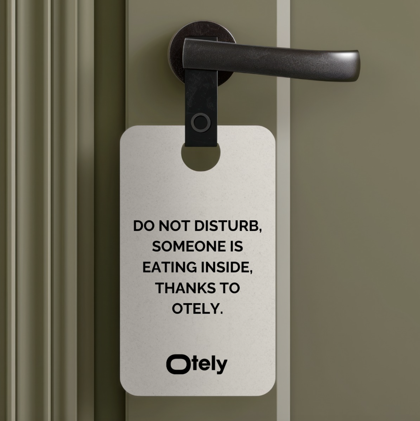 Accroche-porte d’hôtel accroché à une poignée noire, avec le message 'DO NOT DISTURB, SOMEONE IS EATING INSIDE, THANKS TO OTELY.' Le logo Otely est affiché en bas du panneau.