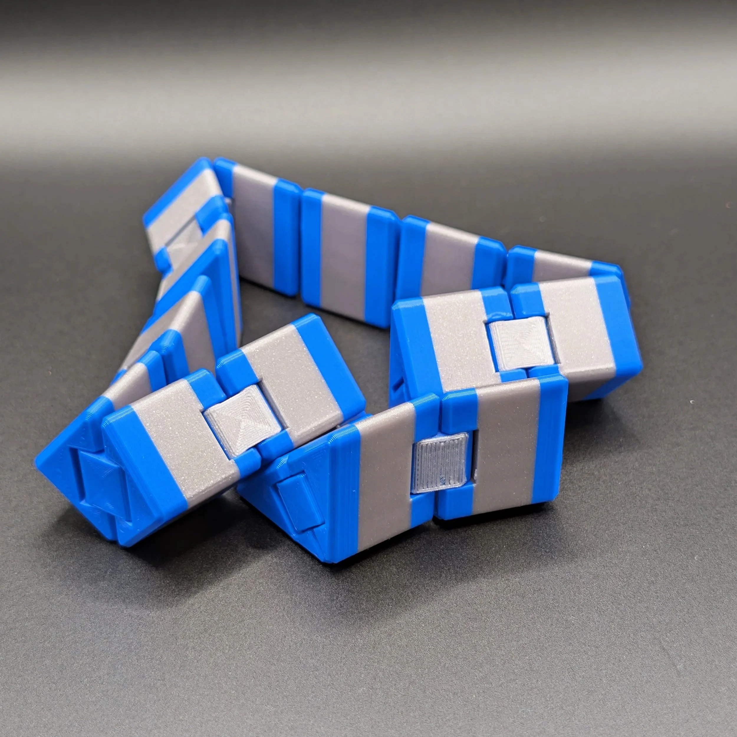 Ultimate Fidget Cube in Blue / Galaxy Grey, zu einer Zickzack-Kette entfaltet – die Klappmechanik des 3D-gedruckten Fidget Toys