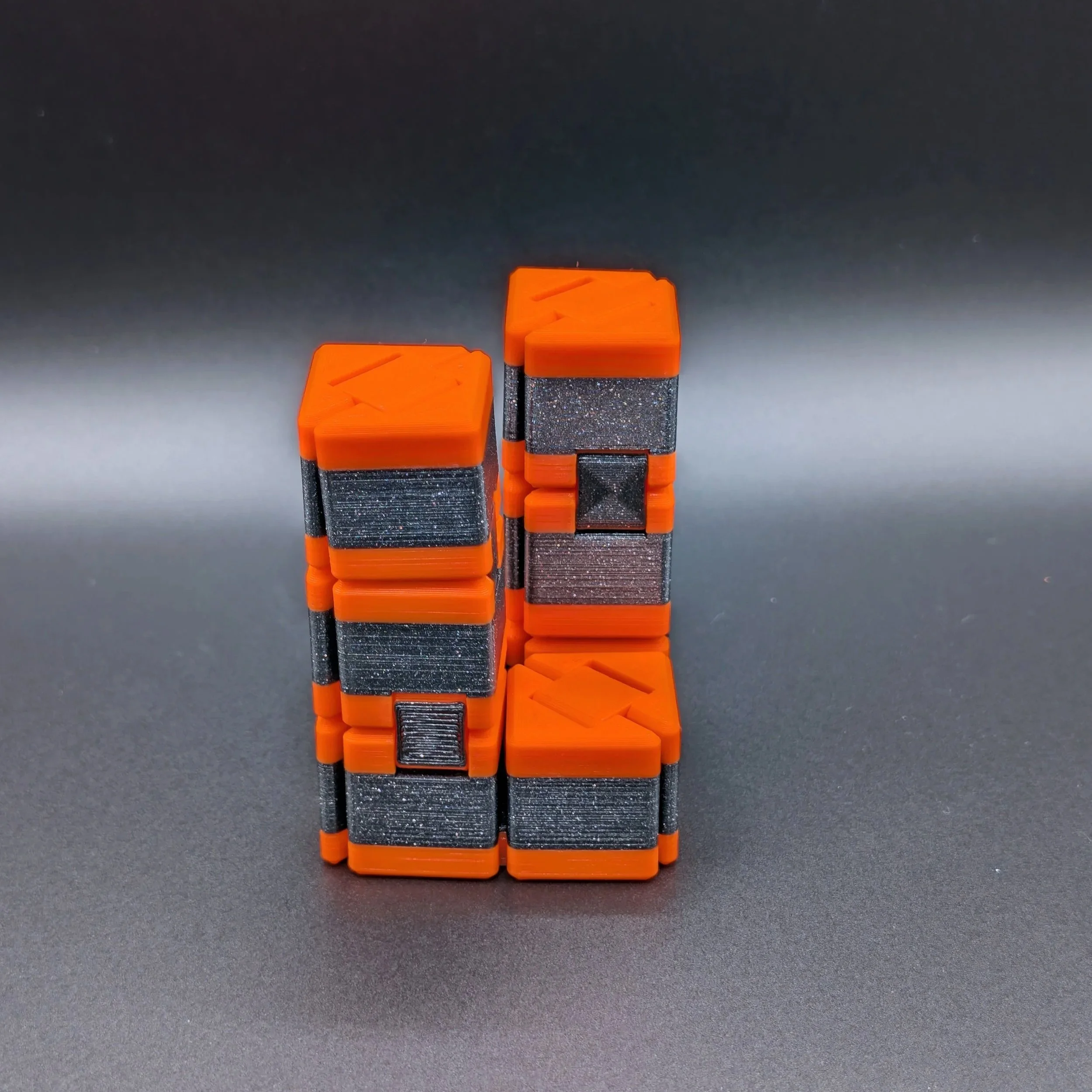 Ultimate Fidget Cube in Prusa Orange / Galaxy Black, zu zwei Türmen aufgefaltet – 3D-gedrucktes Fidget Toy mit Klappmechanik