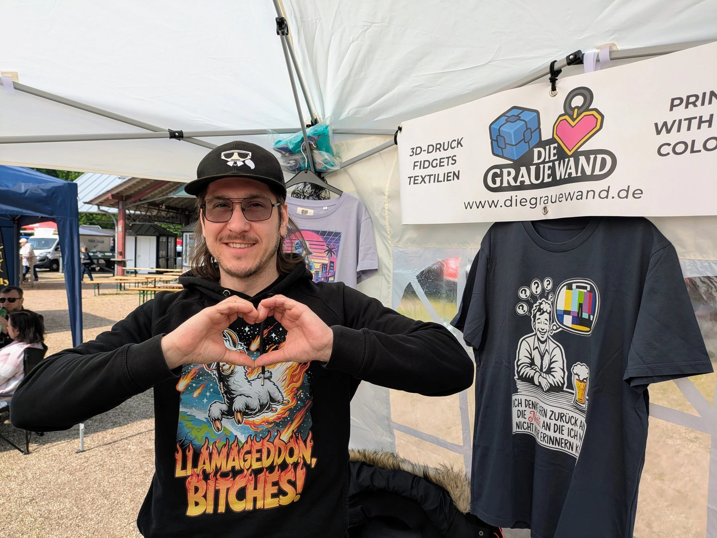 Sönke Dentz, Gründer von Die Graue Wand, am Marktstand mit 3D-Druck-Fidgets und Textilien