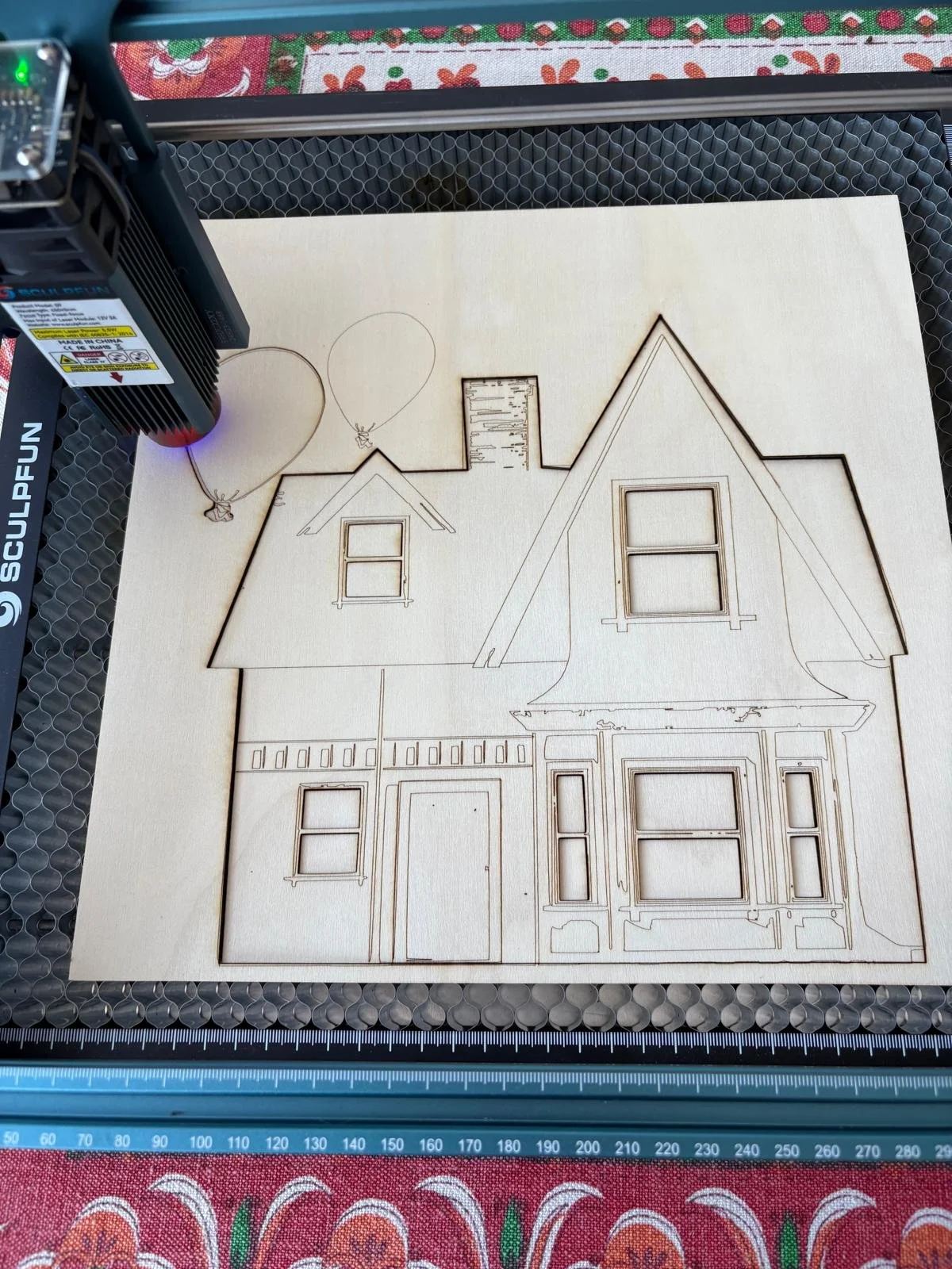 Disegno di una casa in legno con due finestre e una porta, con palloncini disegnati sul soffitto.