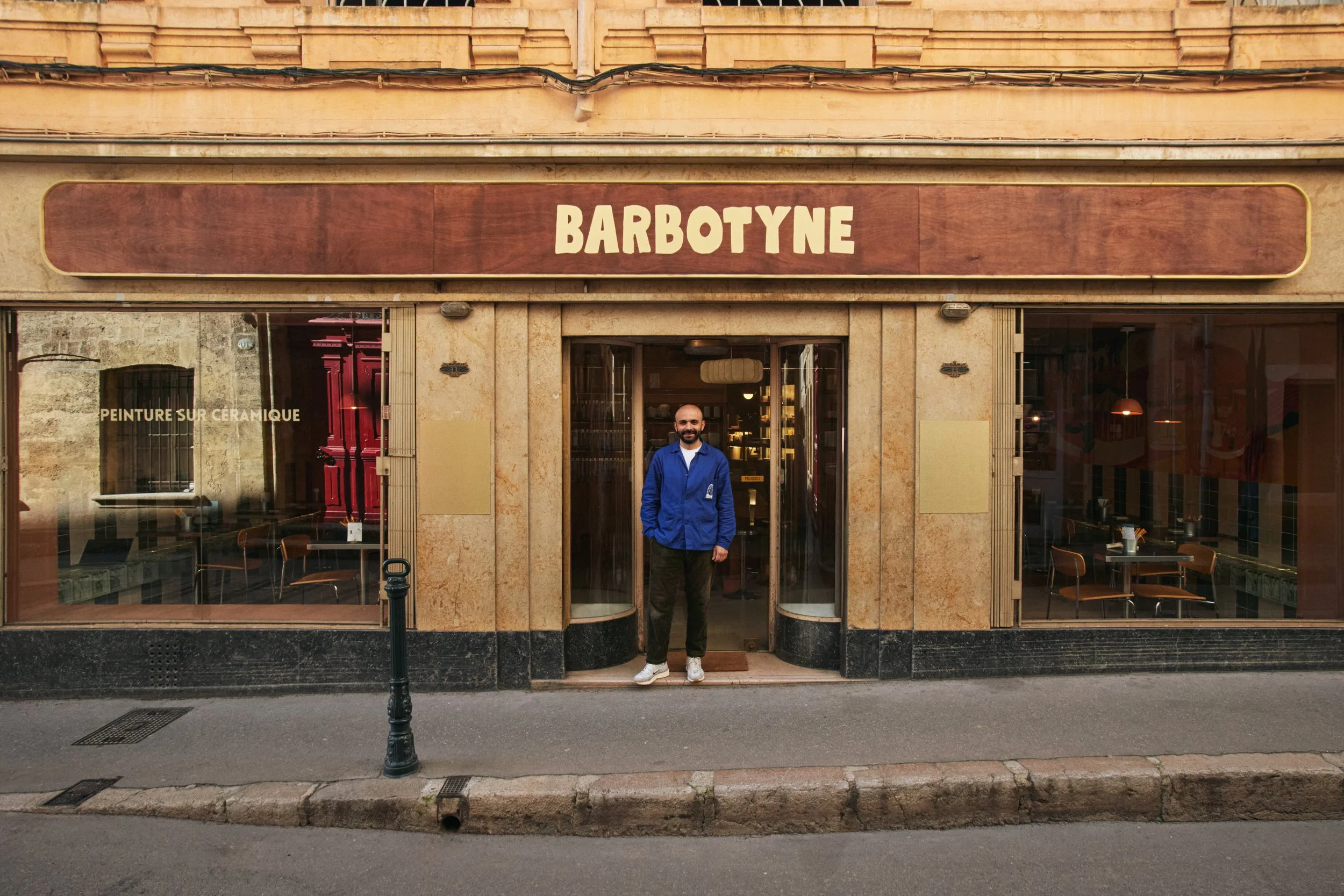 Façade du café-atelier Barbotyne à Aix-en-Provence, conçue pour s’intégrer dans son environnement tout en affirmant une identité visuelle forte.
Le travail sur l’enseigne, les matériaux et les proportions permet de créer une présence juste dans la ru