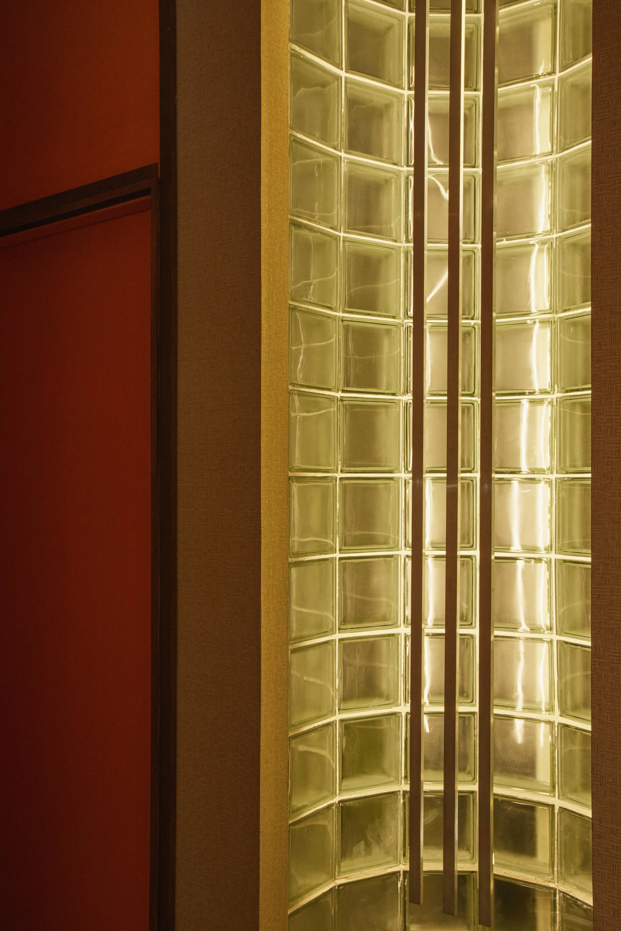 Détail architectural en pavés de verre rétroéclairés dans un centre de détatouage laser à Marseille, conçu par Local Club. Jeu de lumière et transparence pour apporter douceur et intimité dans l’espace.