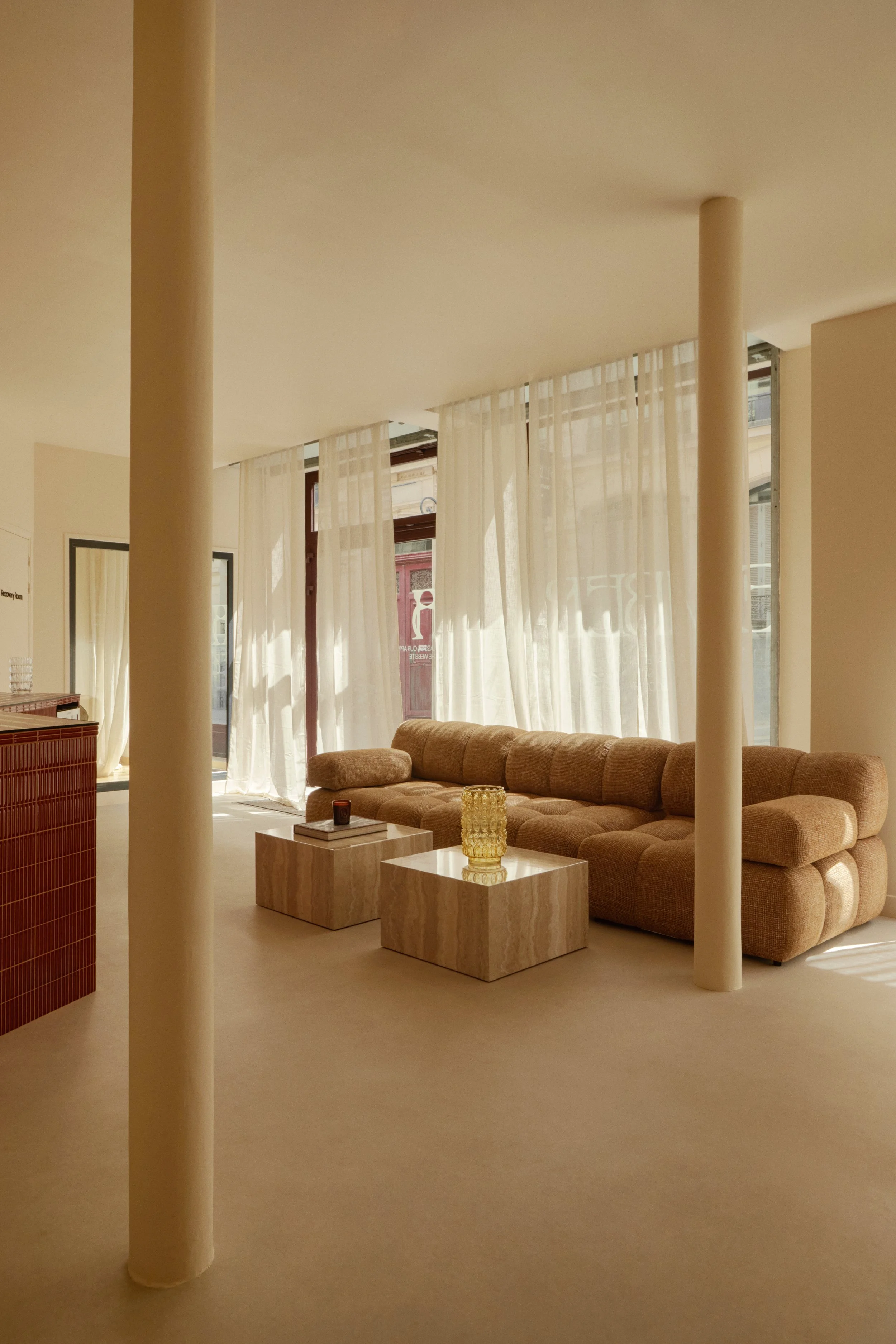 Architecture intérieure d’un studio wellness à Paris, avec salon d’accueil, rideaux légers, mobilier chaleureux et ambiance immersive pensée par Local Club.