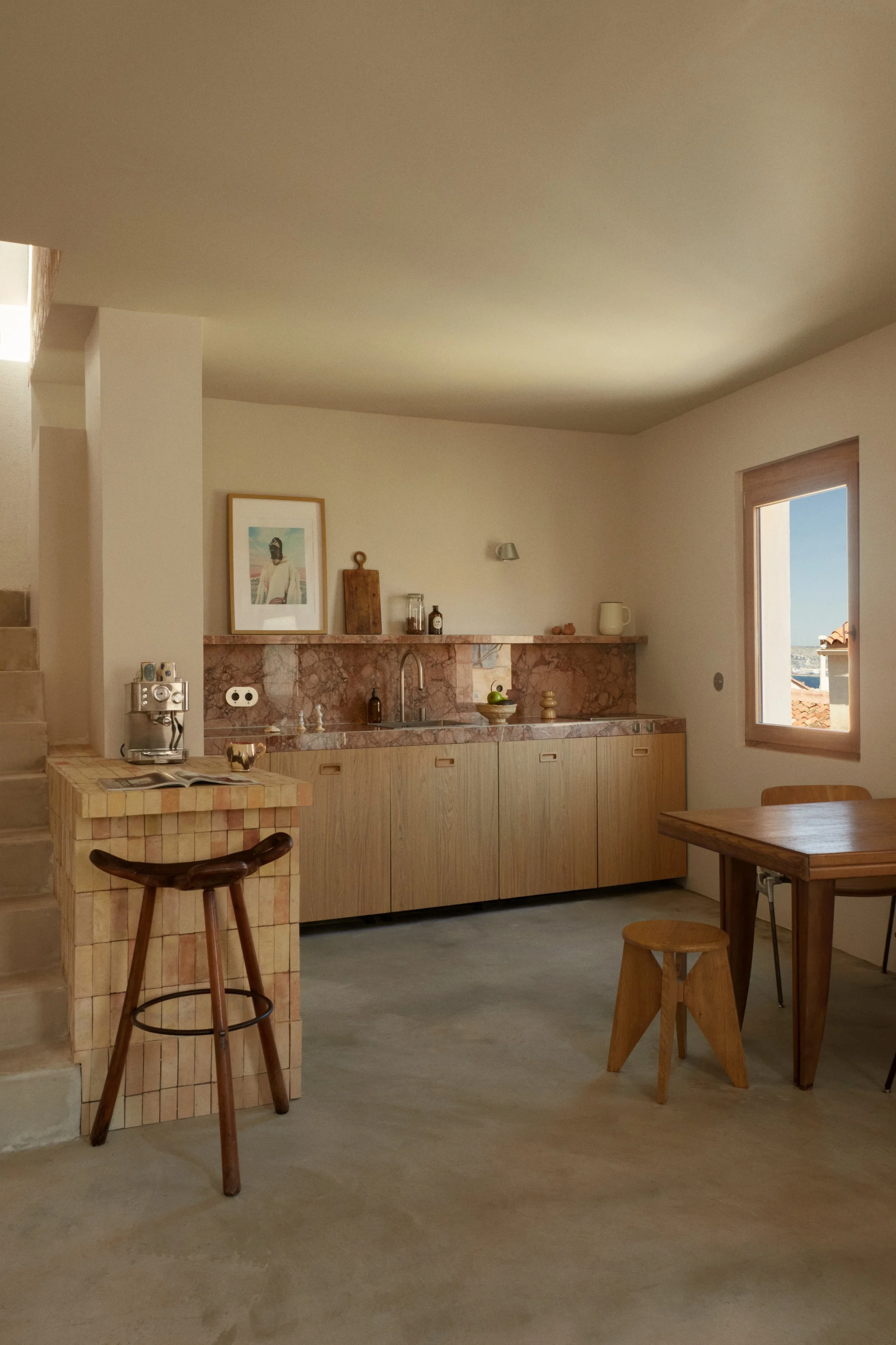 Cuisine sur mesure dans une maison rénovée à Marseille par Local Club. Association de pierre naturelle, bois clair et volumes épurés pour un espace de vie à l’esthétique méditerranéenne contemporaine.