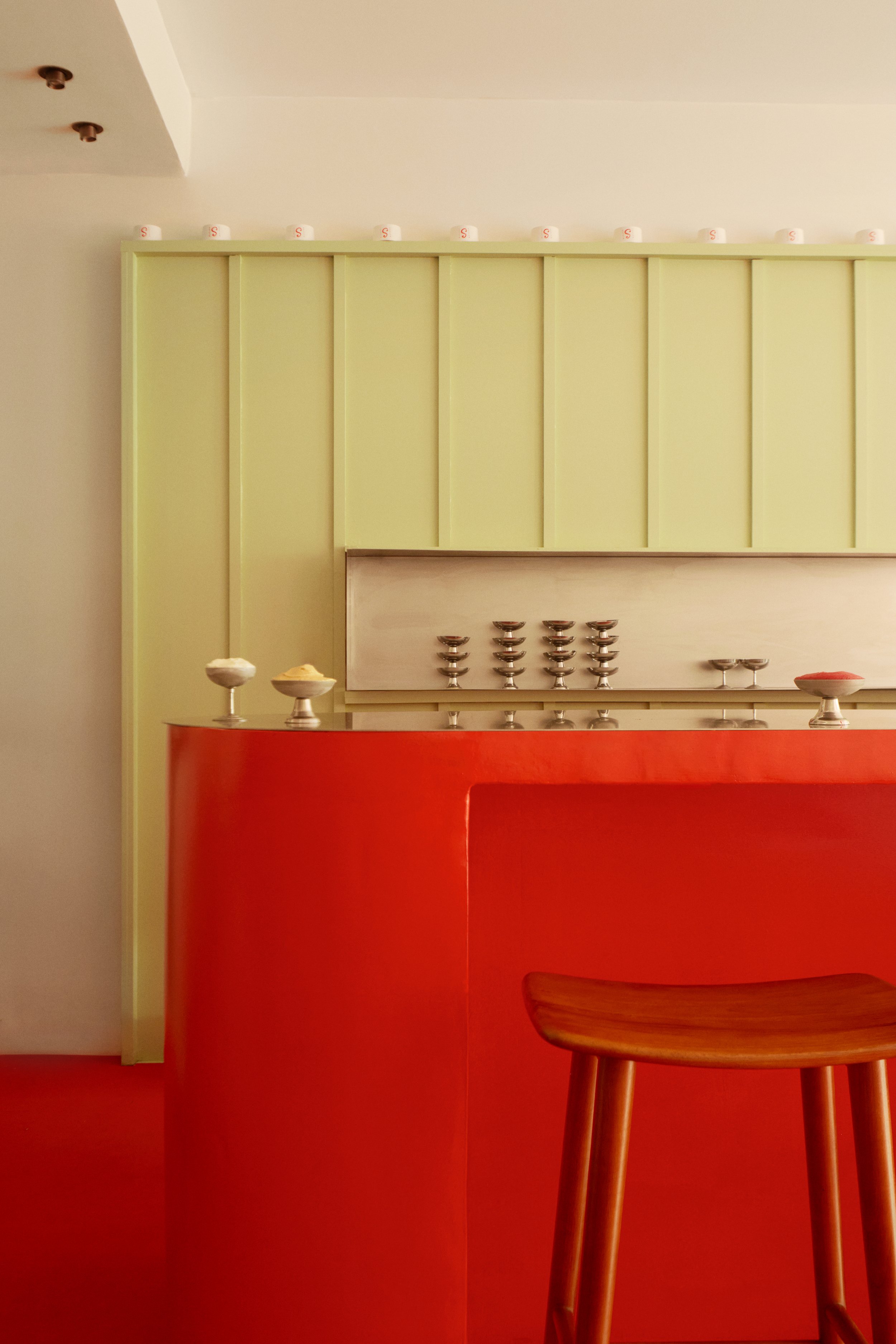 Détail du comptoir rouge et vert du glacier SORO, entre mobilier vintage, mosaïque, métal et palette colorée inspirée des parfums de glace artisanale.