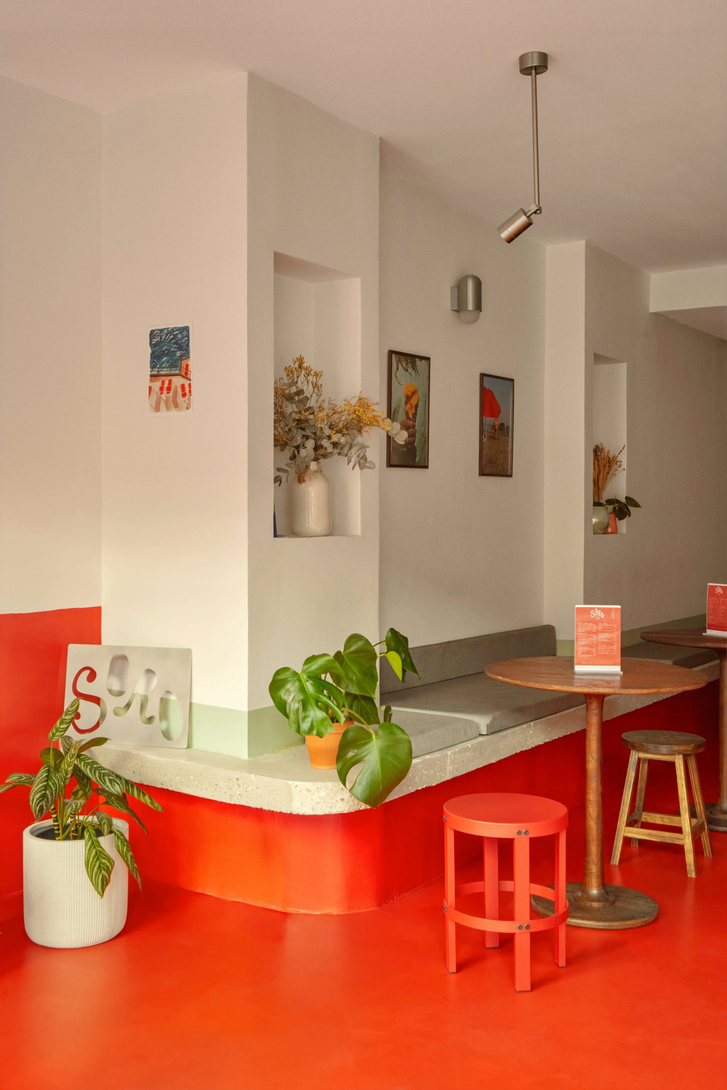 Espace assise du glacier SORO à Marseille, pensé comme un lieu de vie gourmand et convivial avec banquette, tables rondes, végétation et ambiance méditerranéenne.