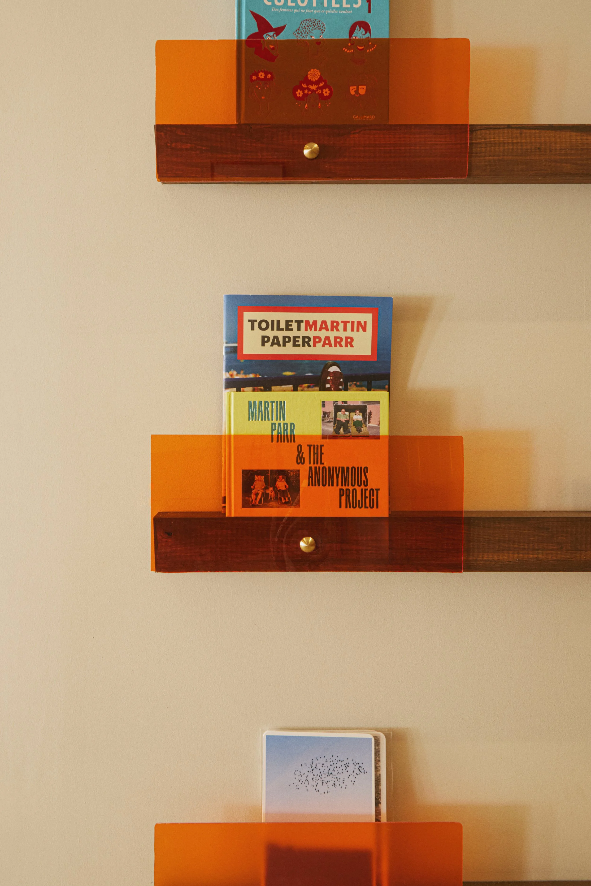 Étagères murales avec sélection d’objets et de livres dans un centre esthétique à Marseille réalisé par Local Club. Jeu de transparence plexi et touches colorées participent à l’identité du lieu.