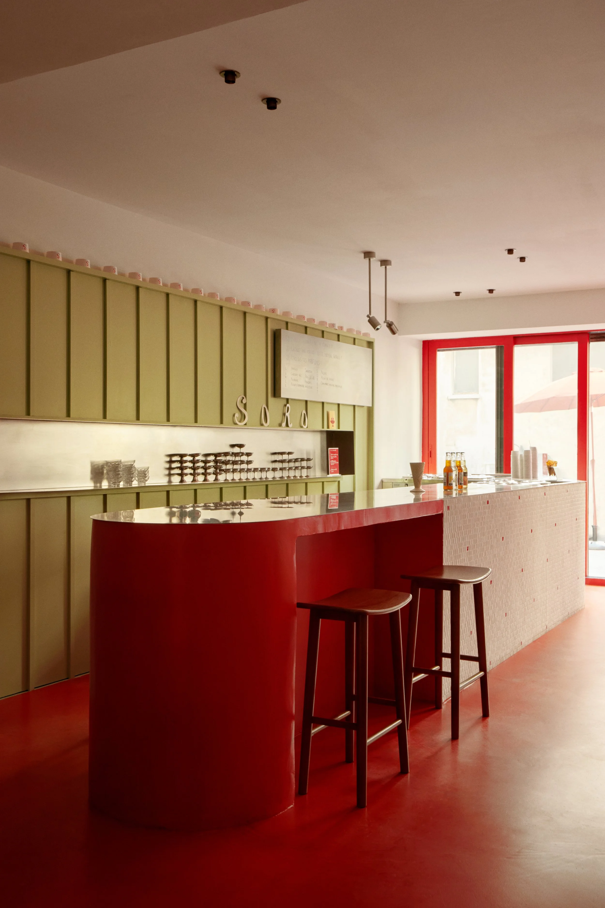 Comptoir rouge et vert du glacier artisanal SORO, conçu par Local Club pour créer une boutique solaire, identifiable et ouverte sur le quartier des Catalans.