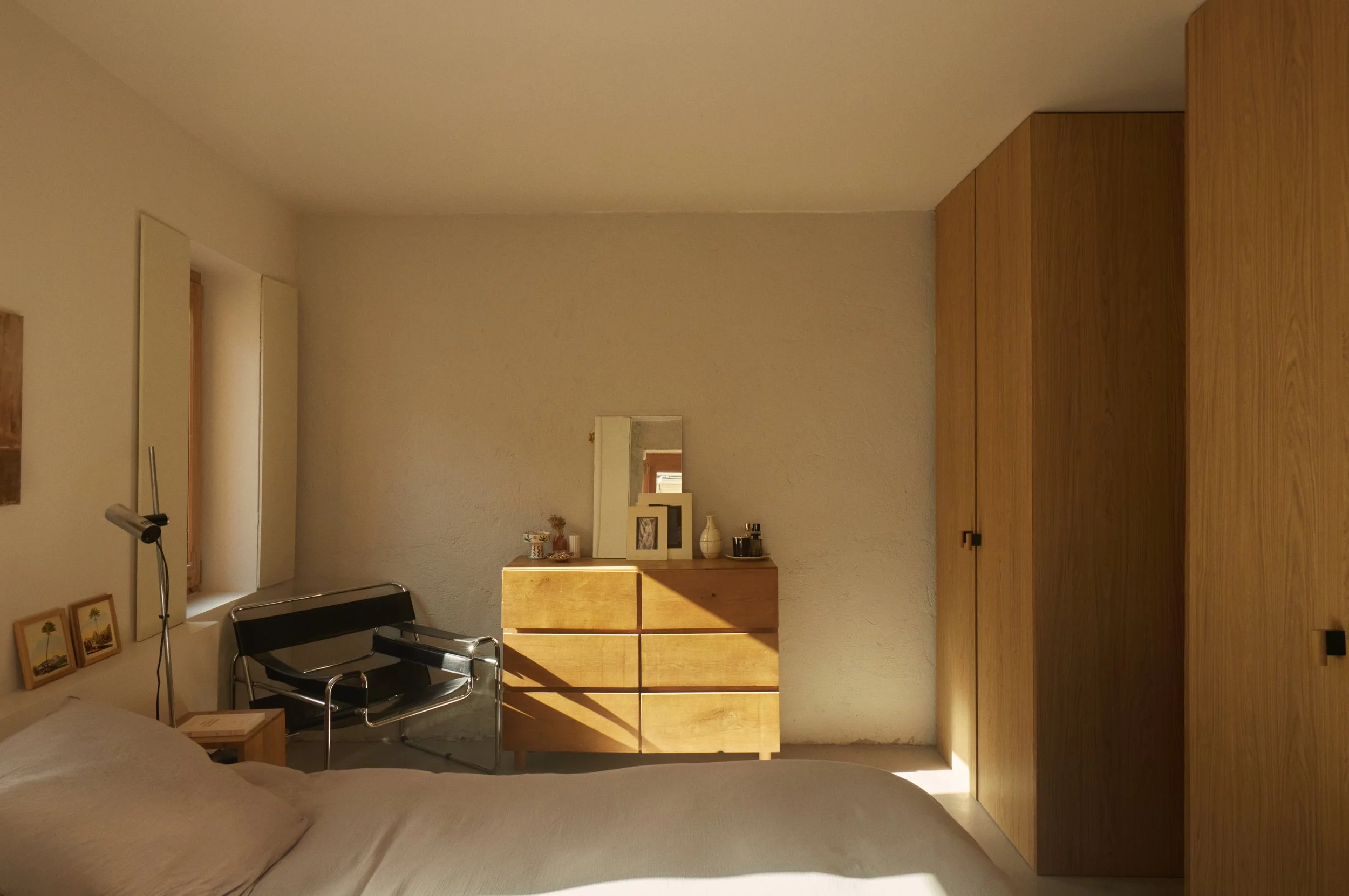 Chambre d’une maison de ville rénovée dans le quartier Samatan à Marseille par Local Club. Volumes épurés, bois naturel et lumière rasante composent un espace sobre et chaleureux, centré sur la matérialité et le calme.
